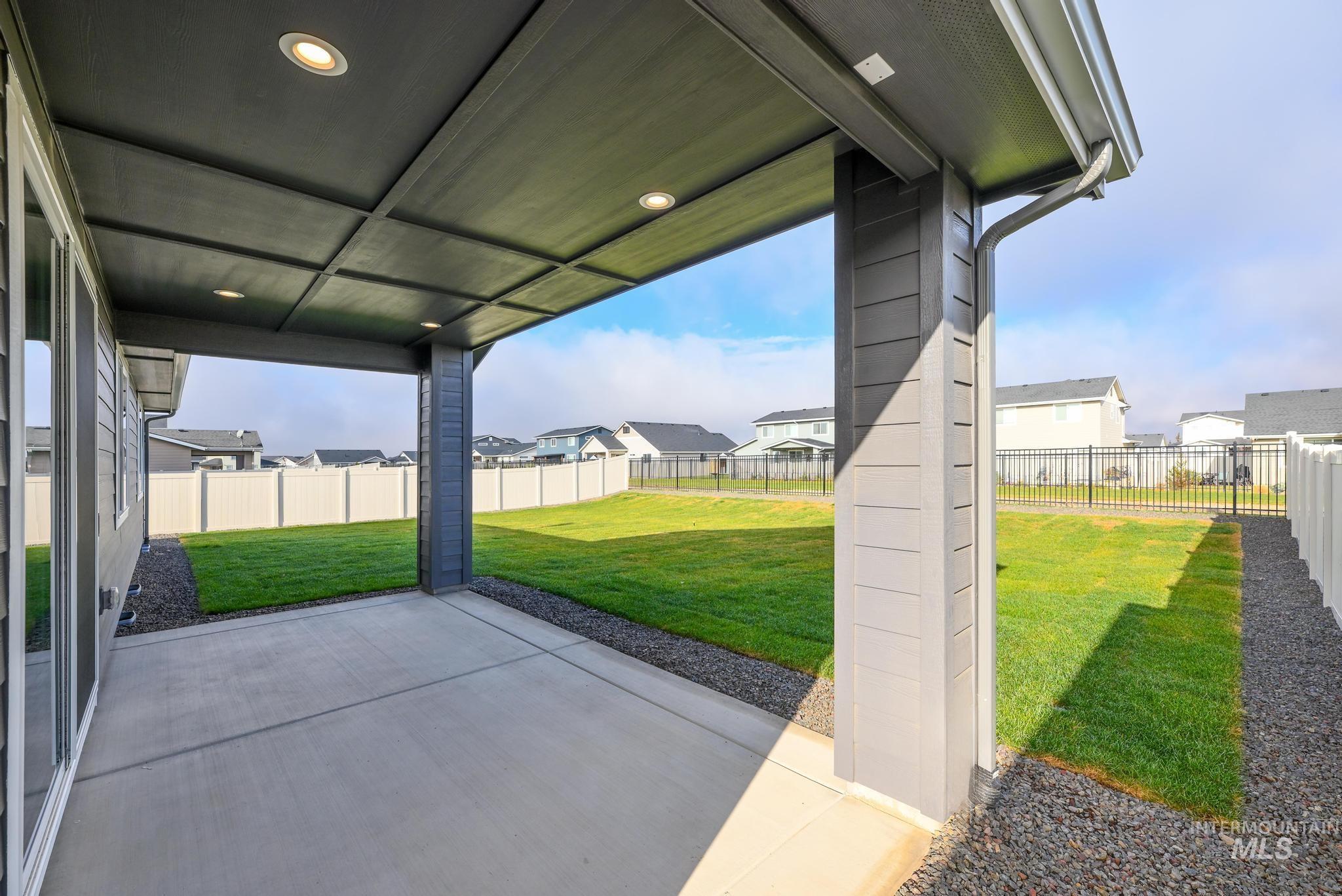 Fenced backyard featuring a patio and a residential view