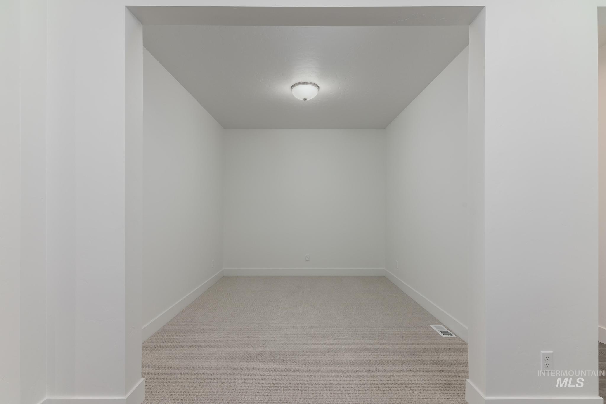 Unfurnished room featuring light colored carpet and baseboards