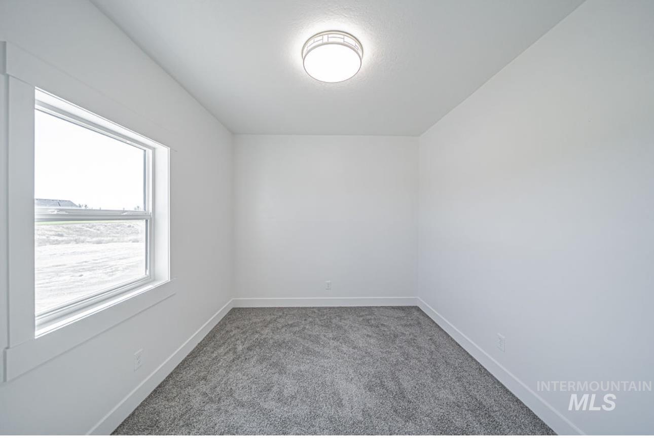Spare room featuring light carpet and baseboards