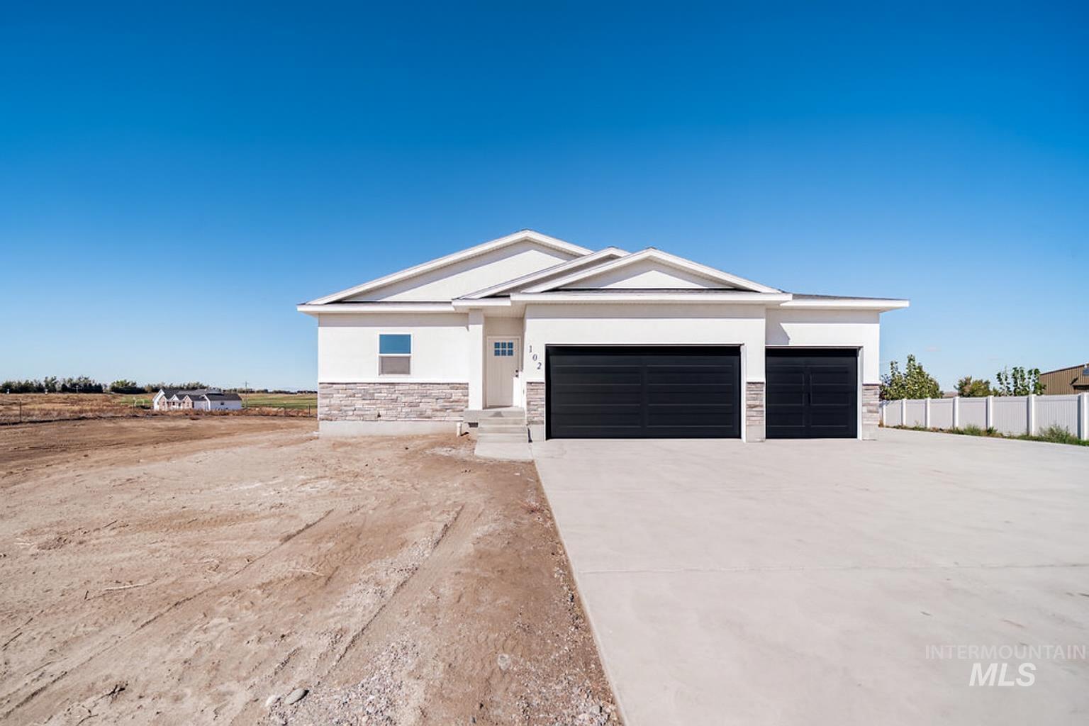 View of front of house featuring stucco siding, stone siding, driveway, and an attached garage