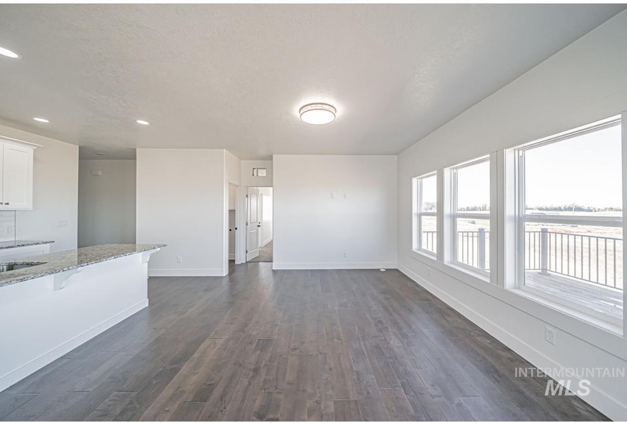 Unfurnished living room featuring dark wood-style floors, recessed lighting, and a textured ceiling