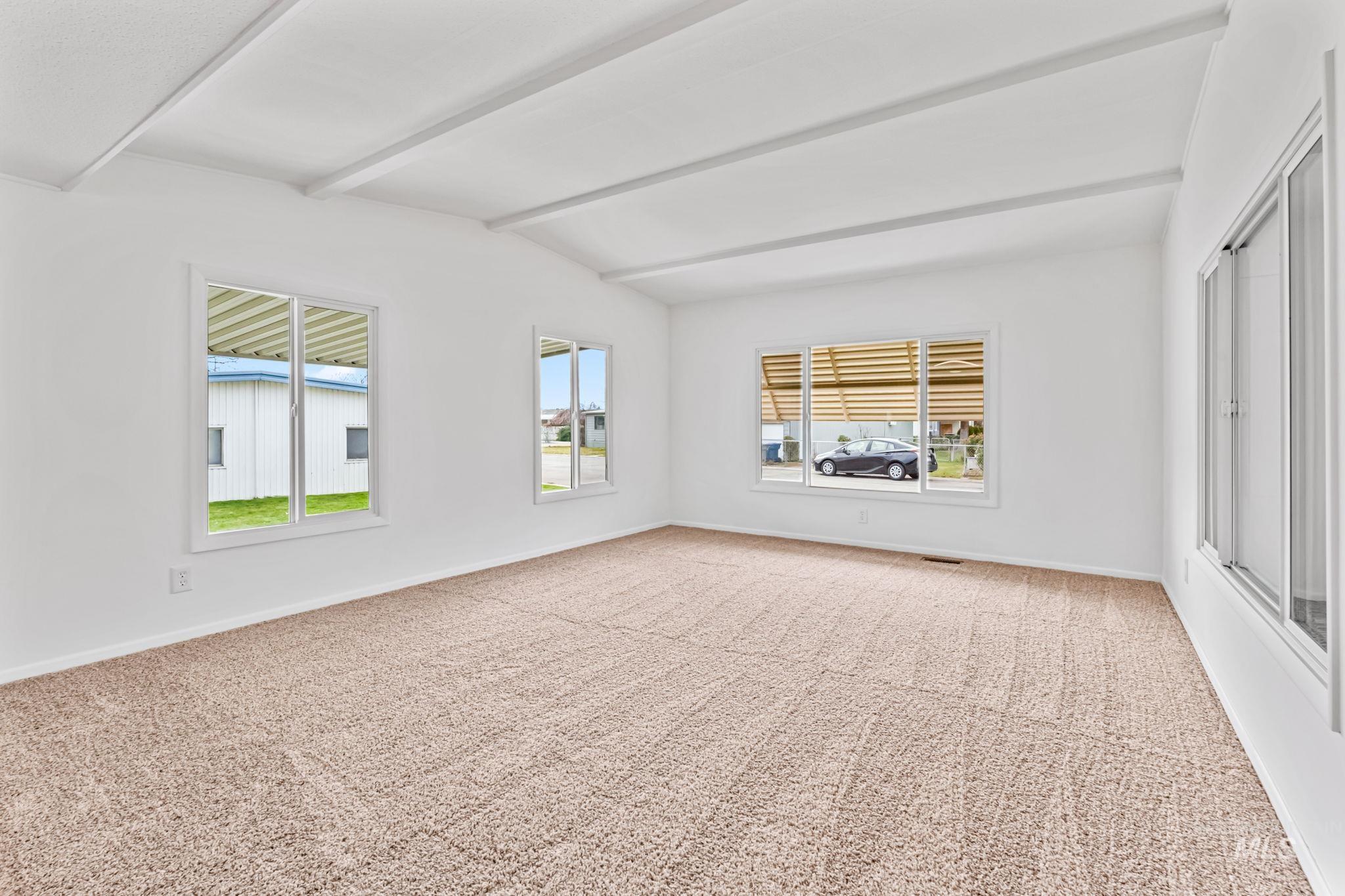 Carpeted empty room featuring plenty of natural light