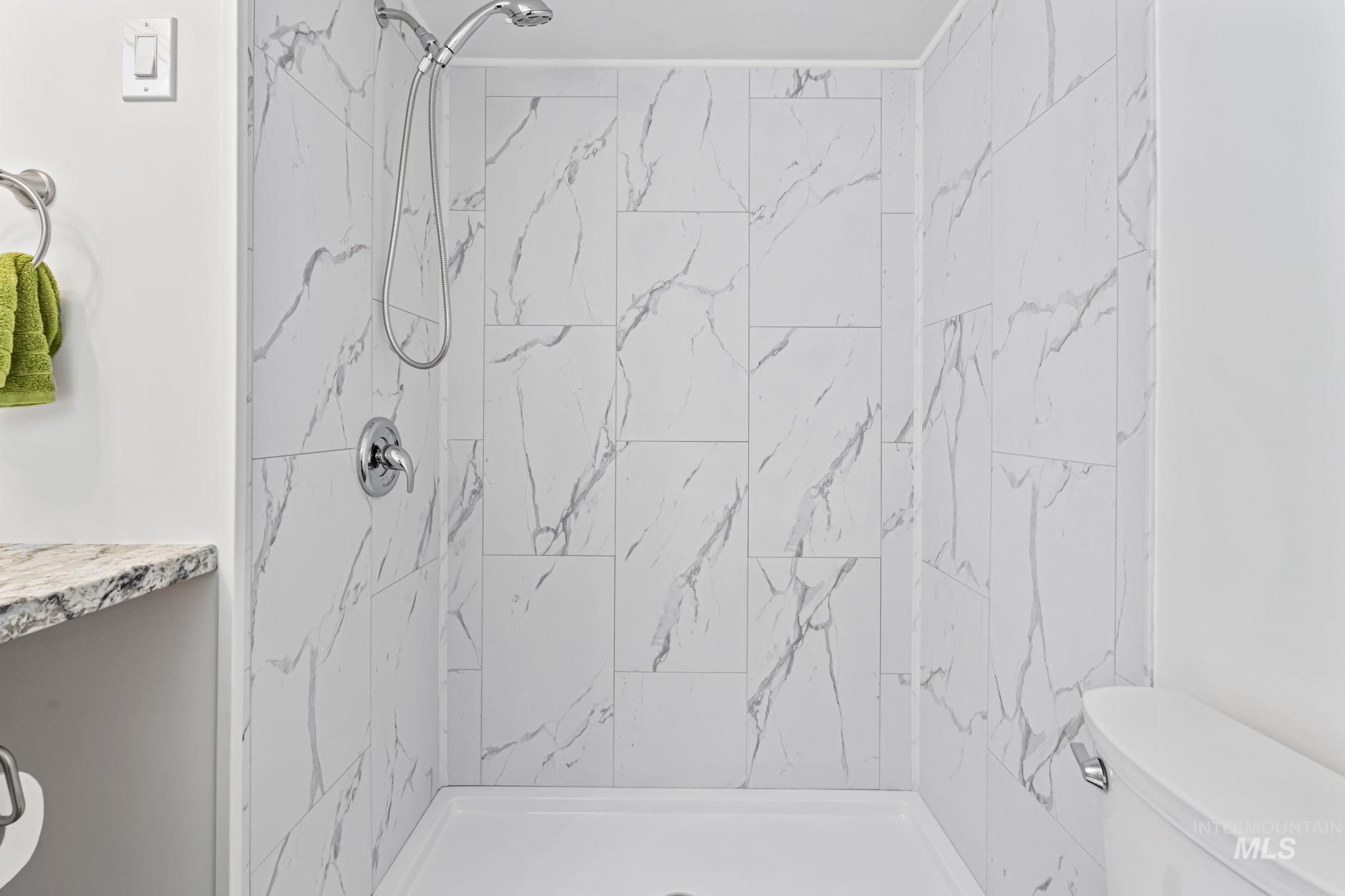 Bathroom with a marble finish shower