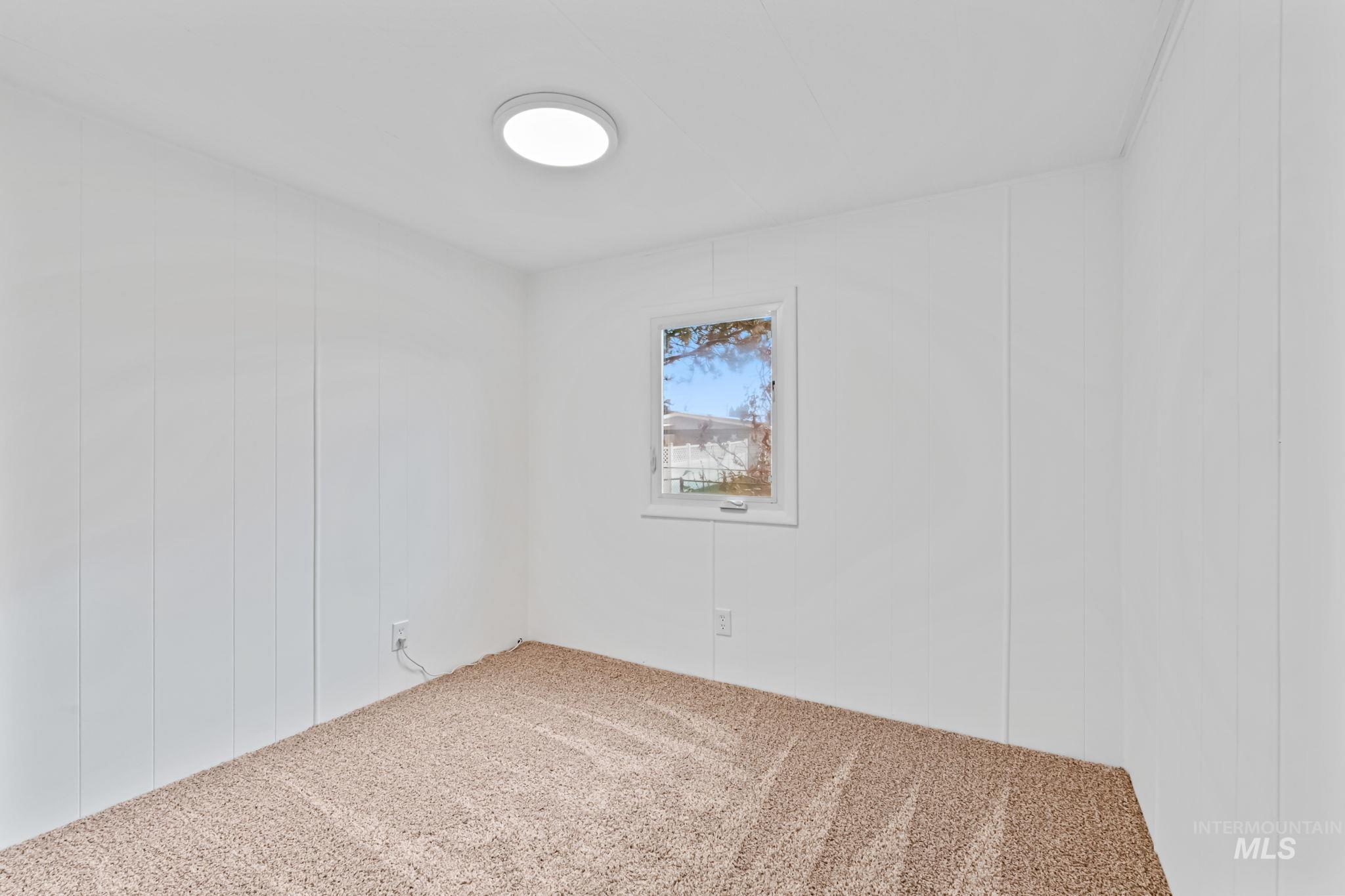 Unfurnished room with a decorative wall and carpet flooring