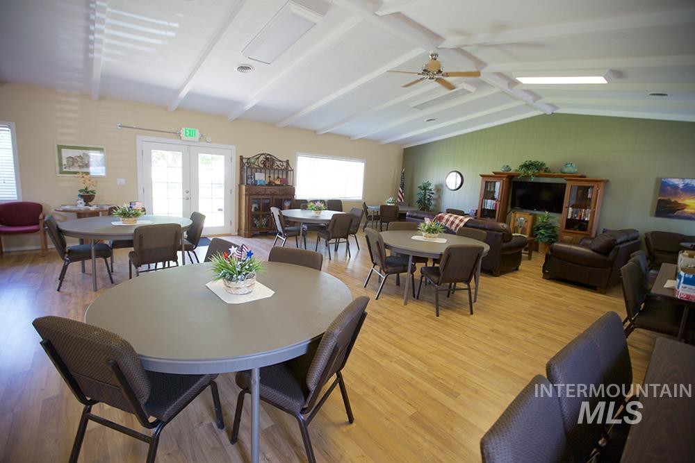 Dining space with french doors, wood finished floors, and a ceiling fan