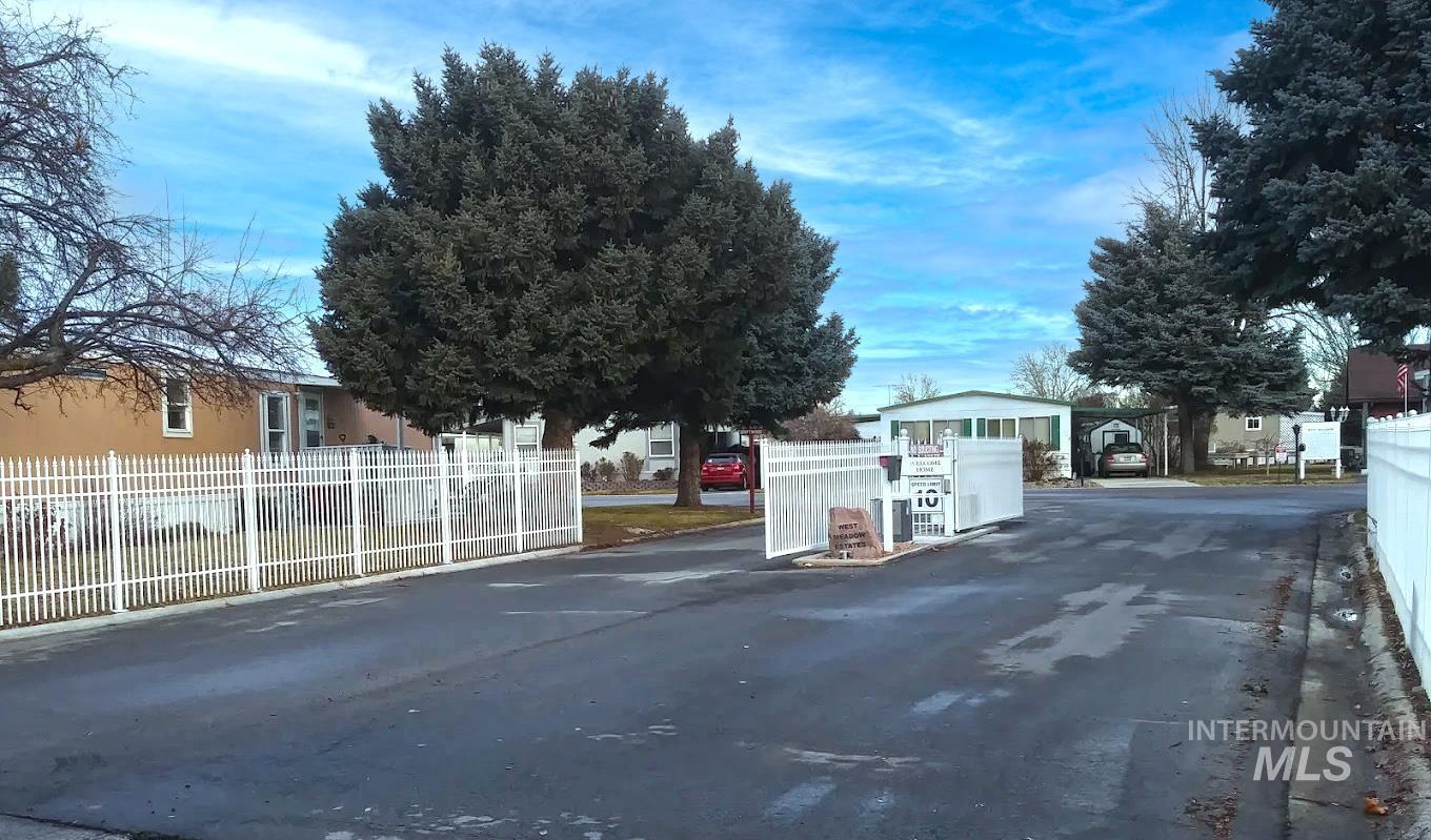 View of asphalt road featuring a residential view and curbs