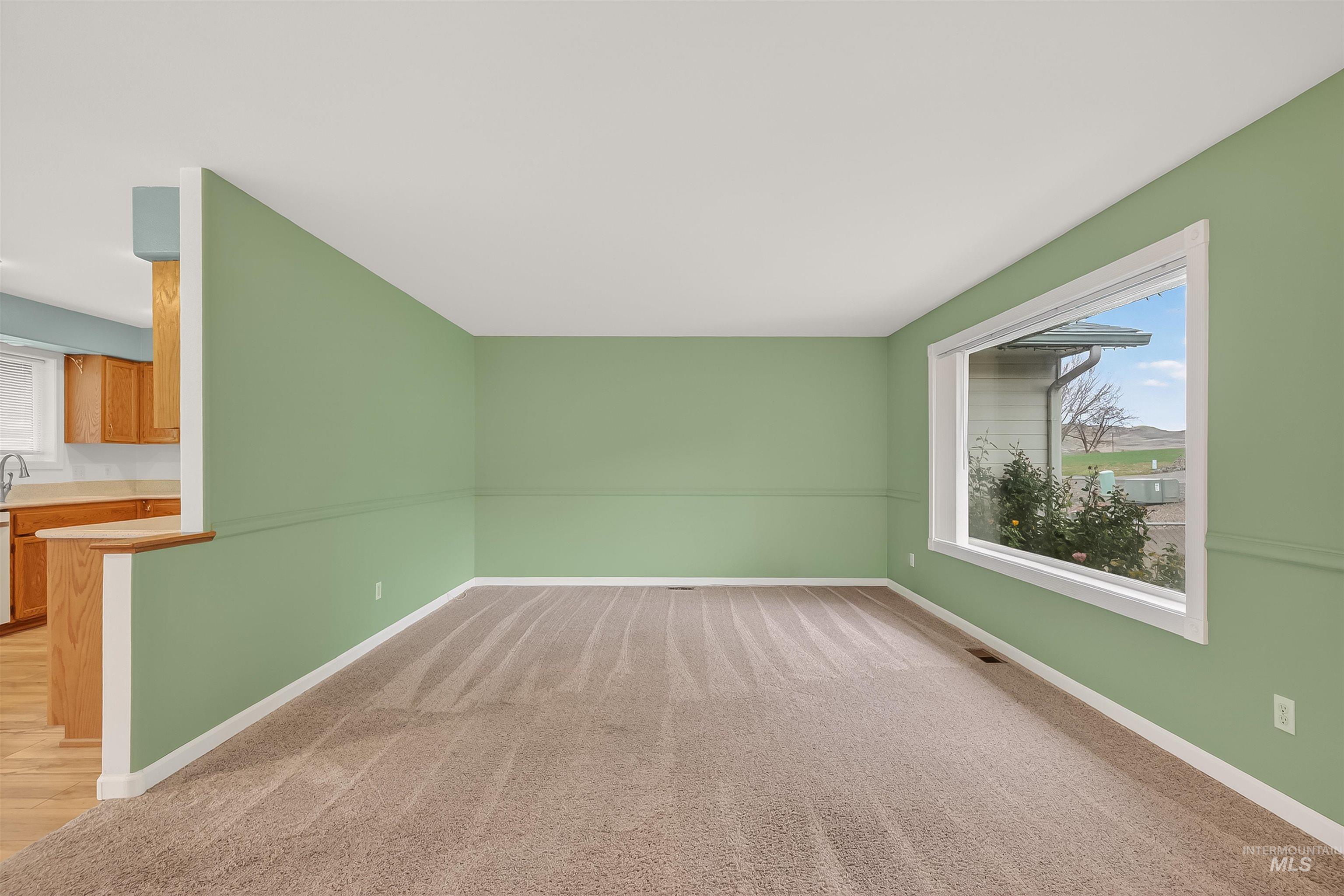 Empty room with baseboards and light colored carpet