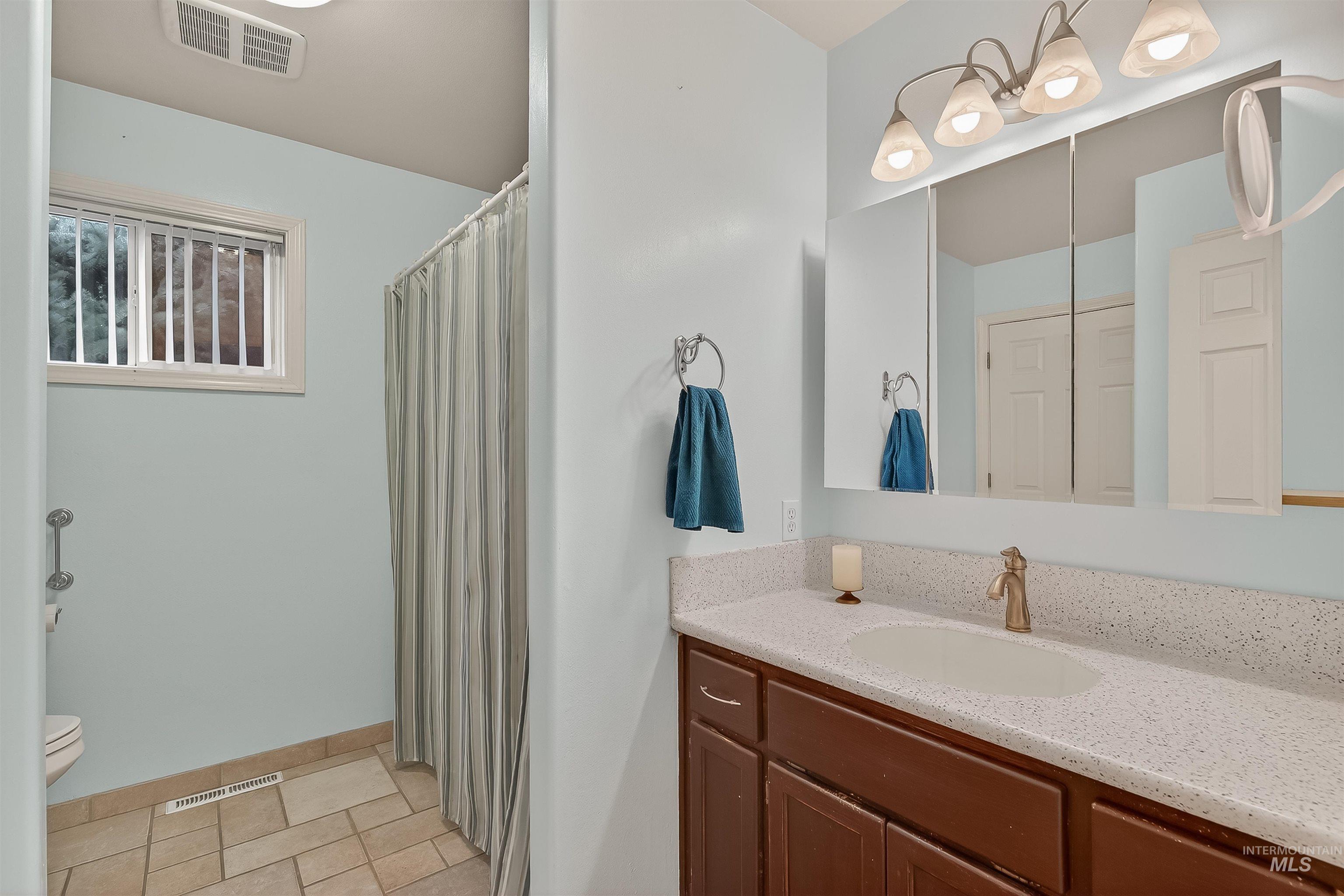 Bathroom with a shower with curtain and vanity