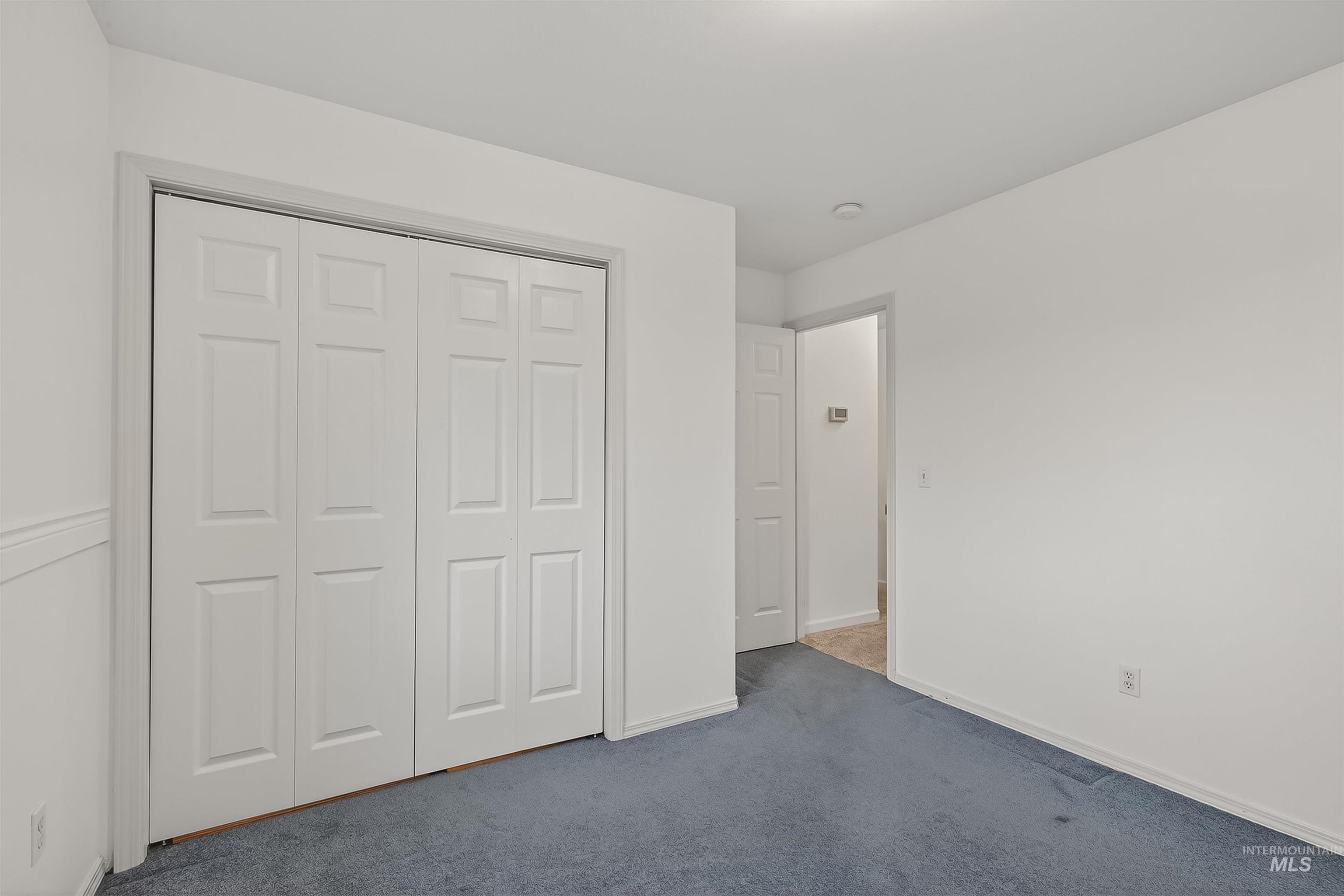 Unfurnished bedroom featuring carpet flooring and a closet