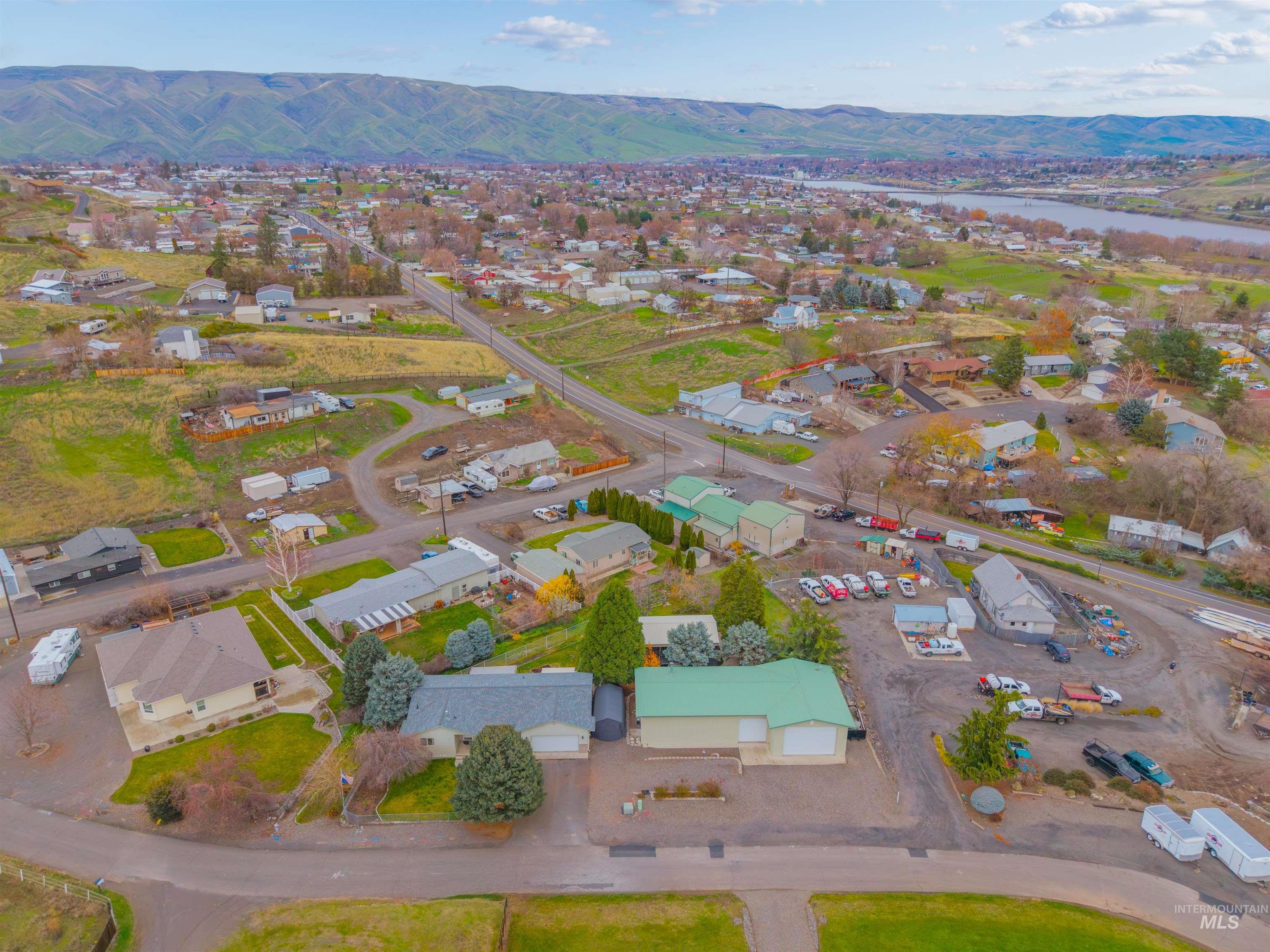 Aerial view of property's location featuring nearby suburban area and a water and mountain view