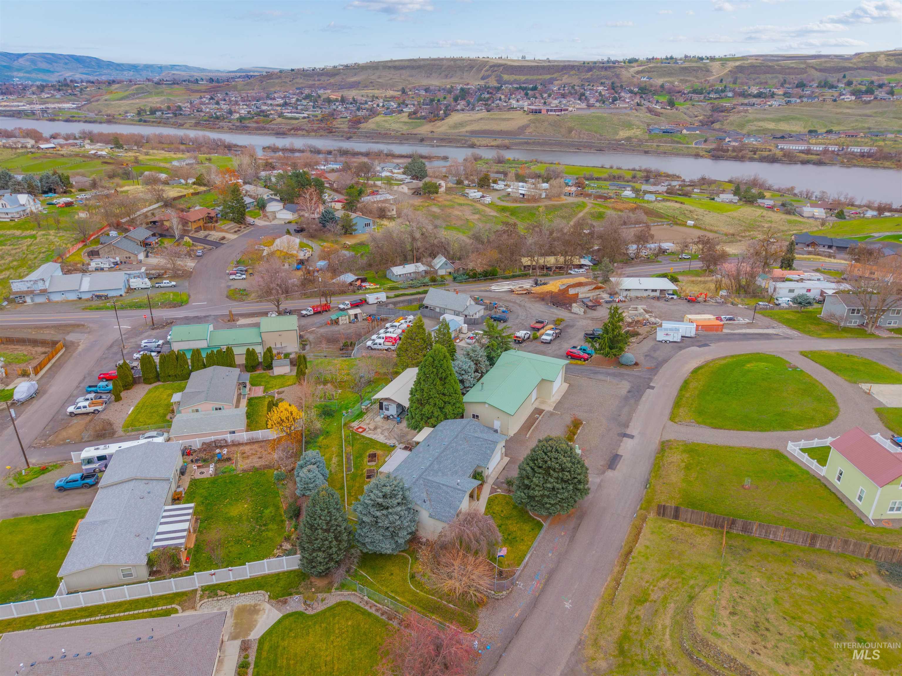 Aerial view of property and surrounding area with nearby suburban area and a nearby body of water
