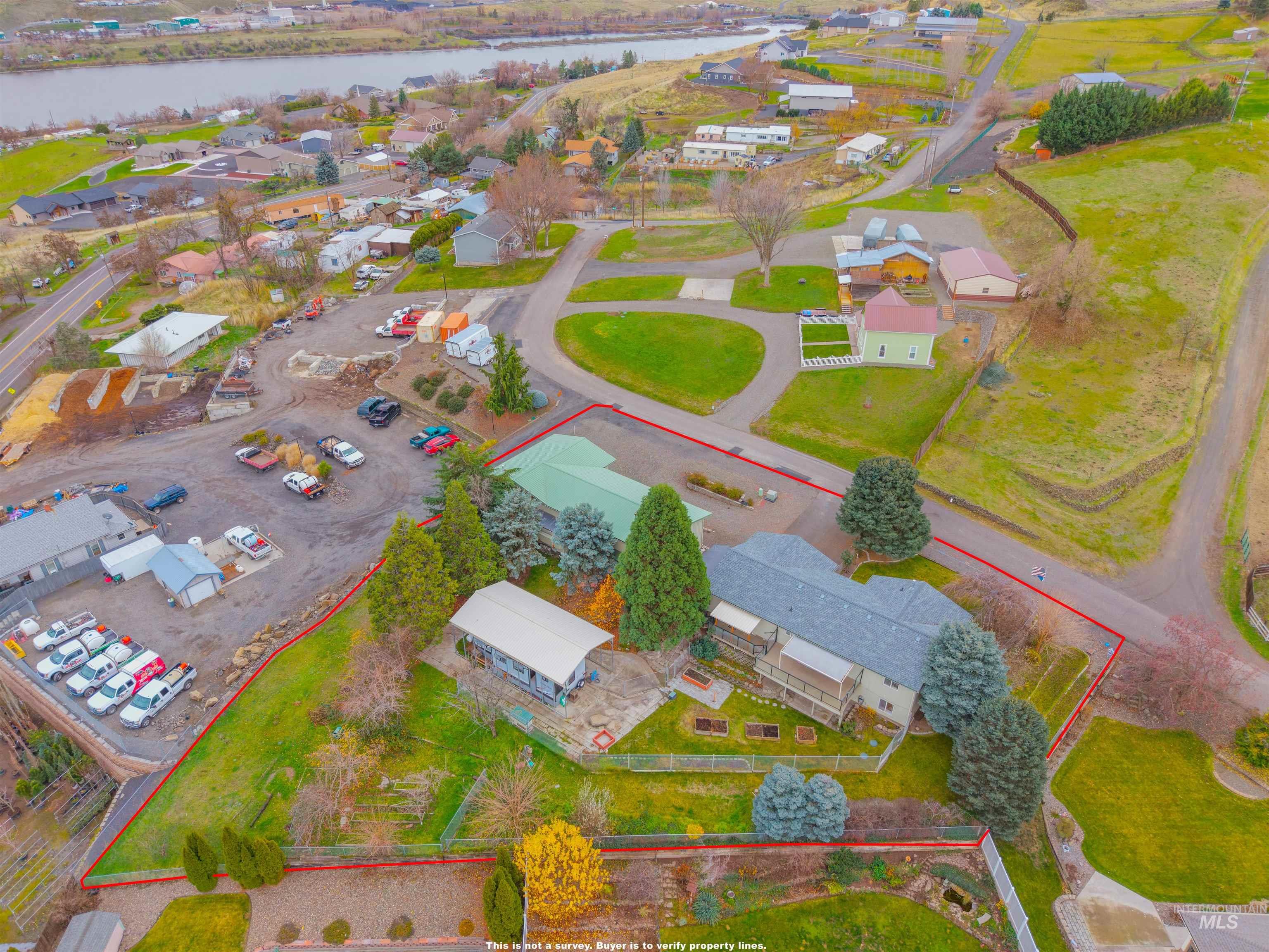 Aerial view of residential area with property parcel outlined and a large body of water
