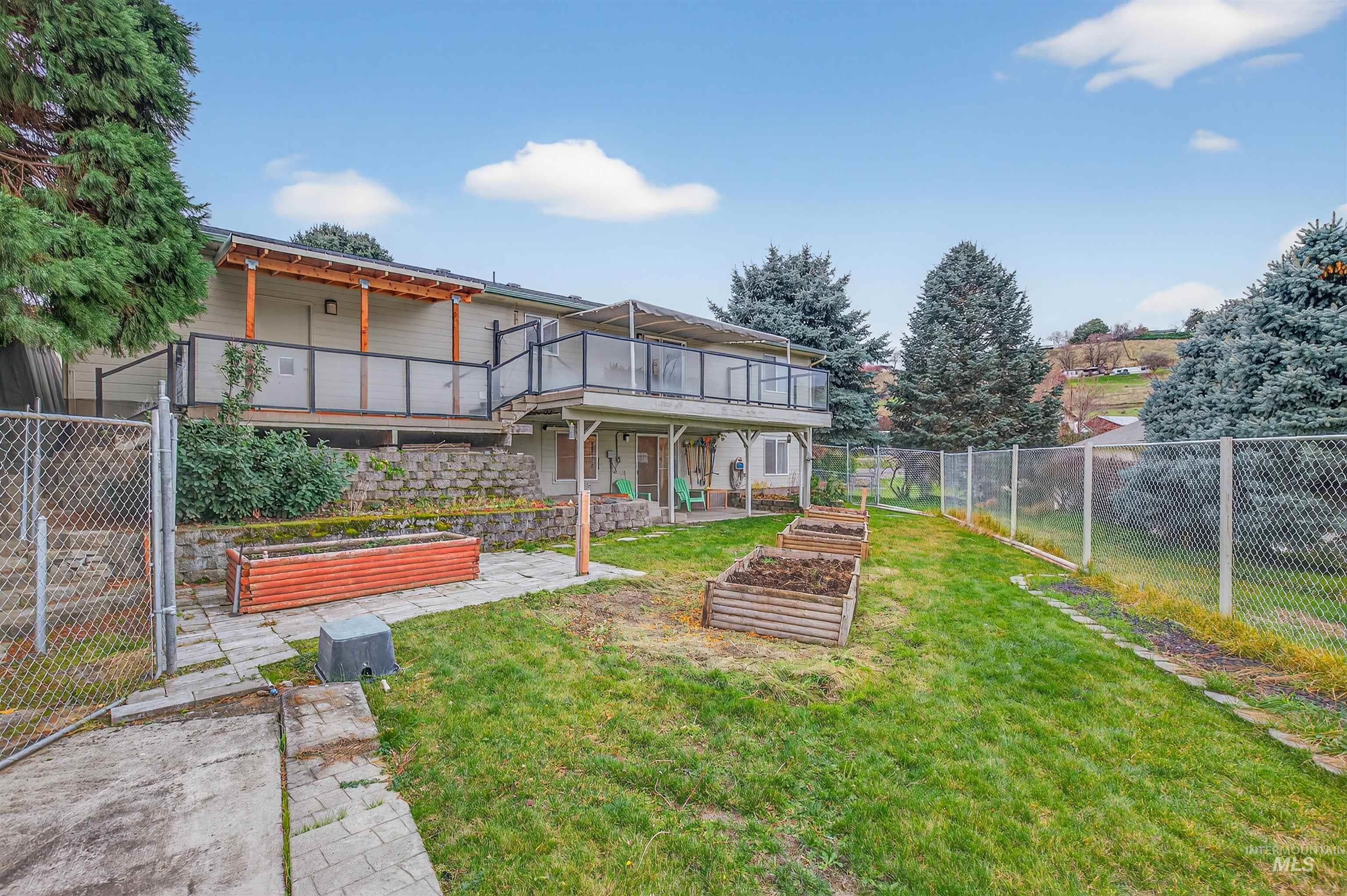 Fenced backyard with a garden, a patio area, and a deck