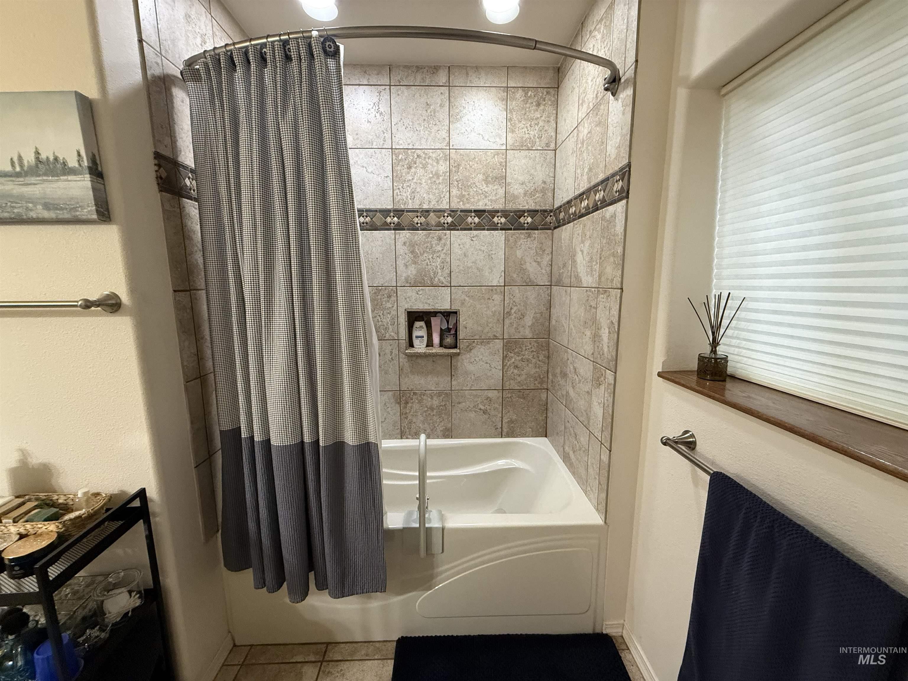 Bathroom with shower / tub combo and tile patterned flooring