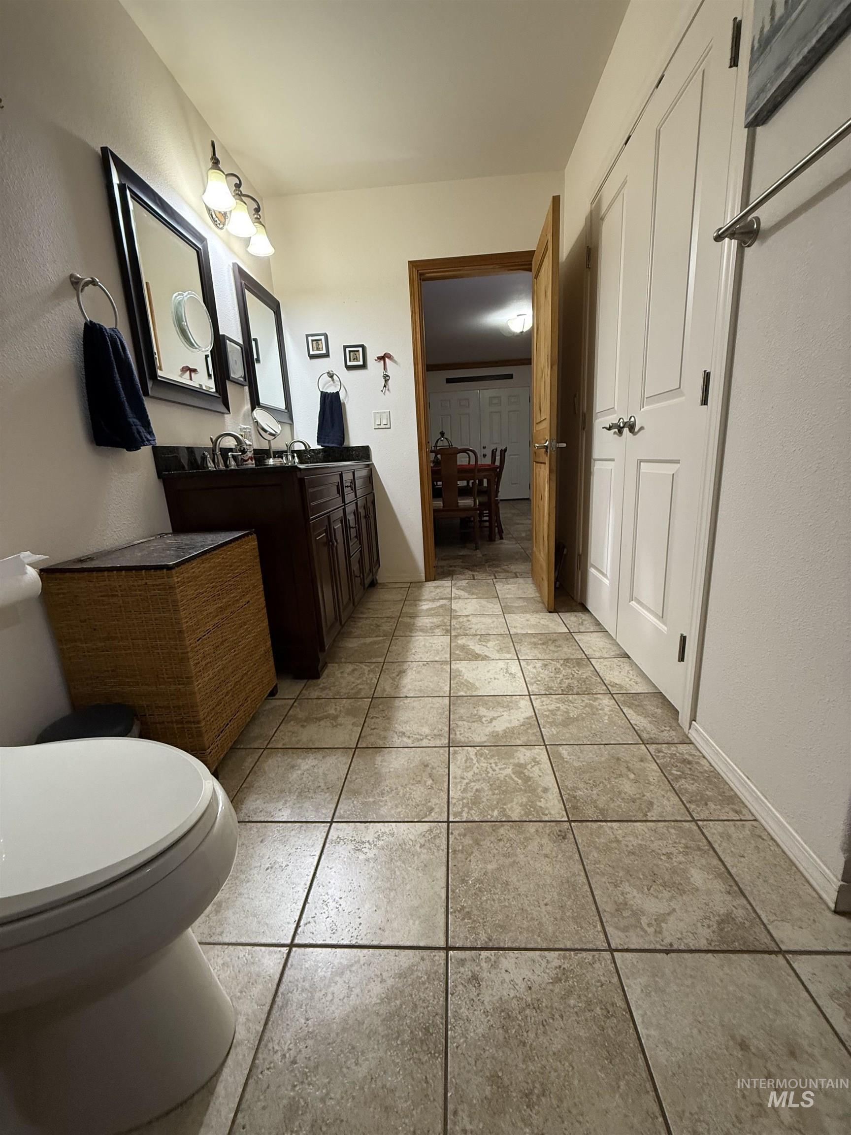 Bathroom with vanity, a textured wall, and light tile patterned floors