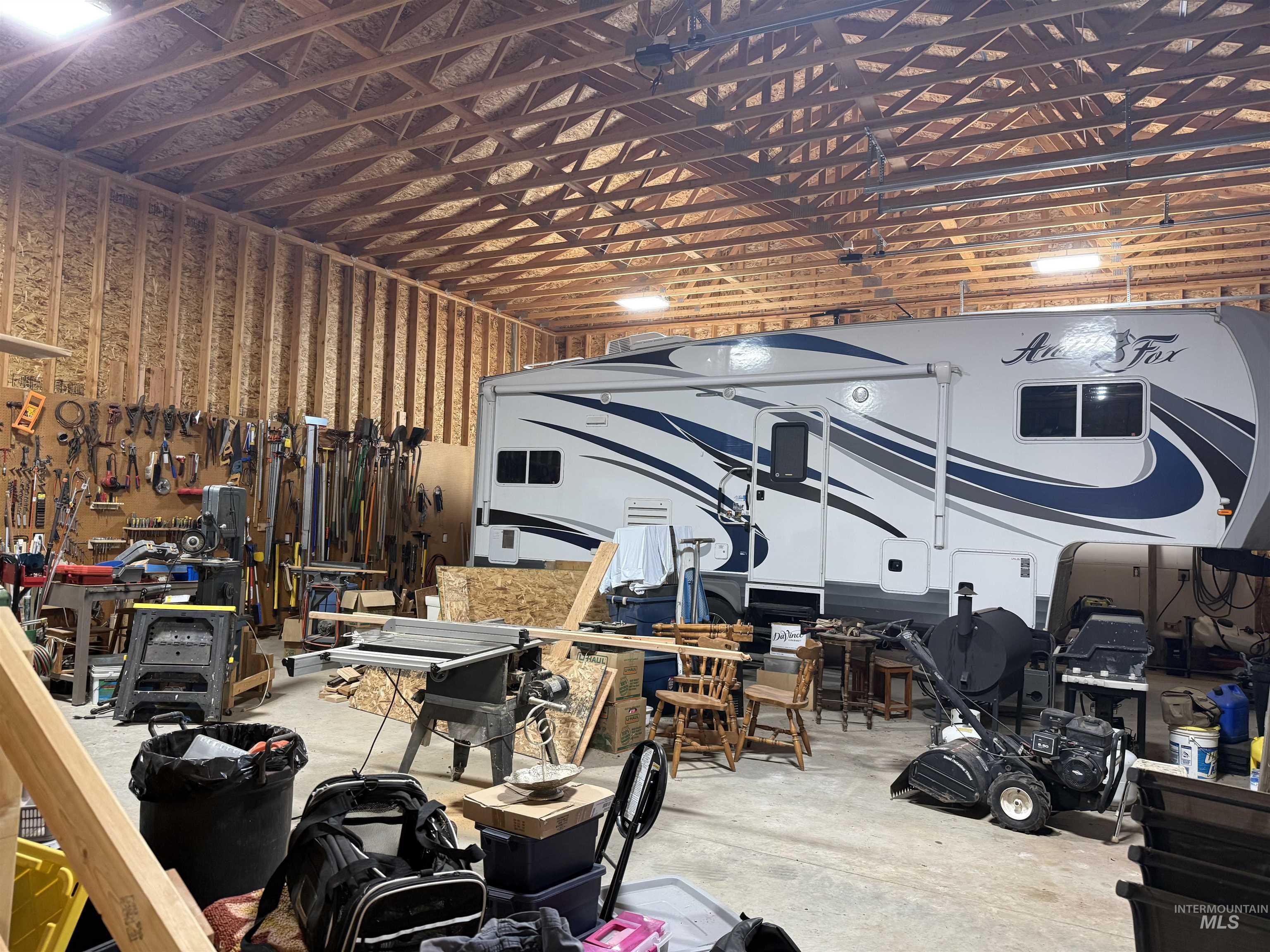 Misc room featuring a workshop area, unfinished concrete flooring, and a garage