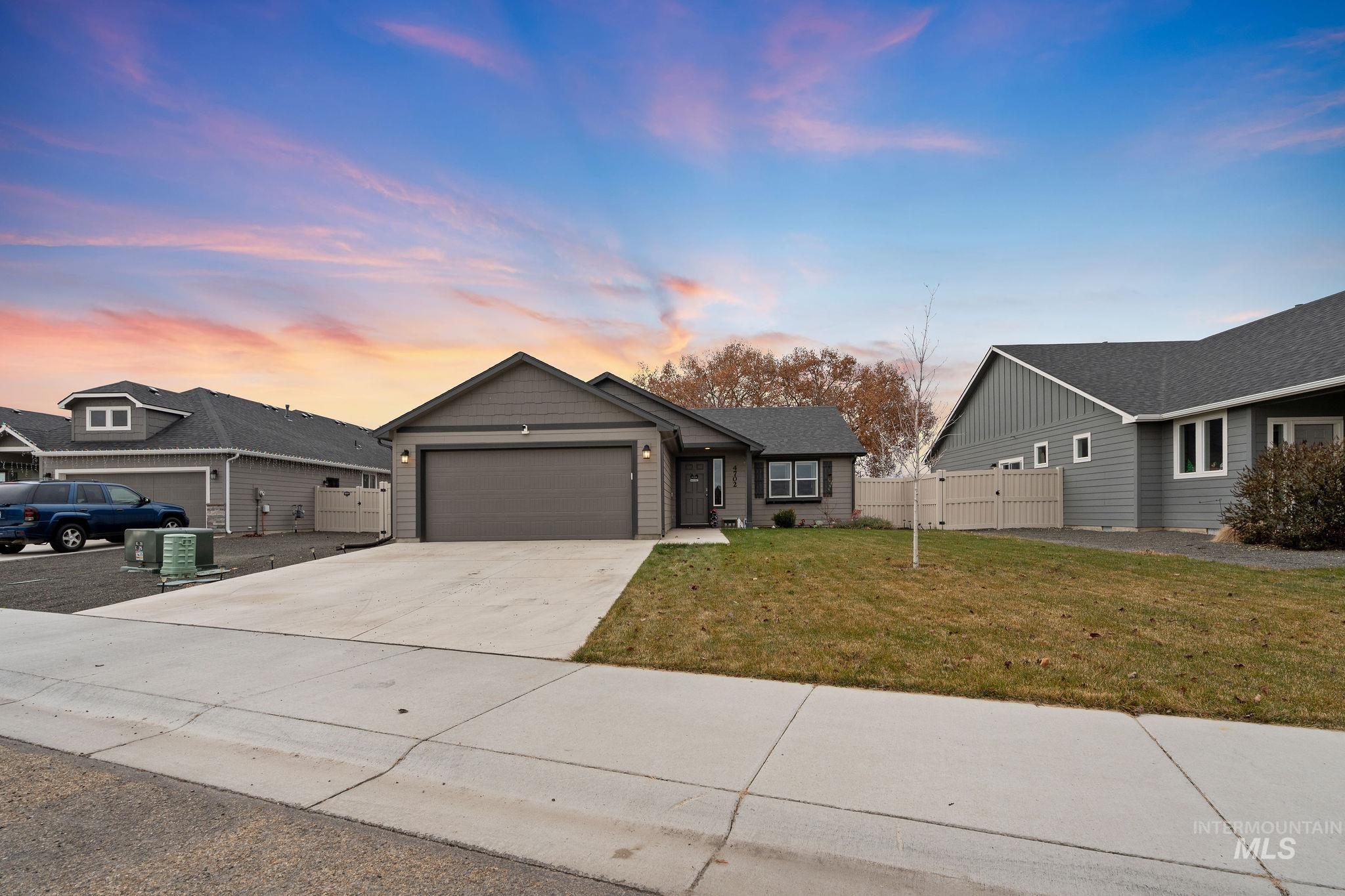 Ranch-style home featuring concrete driveway and an attached garage