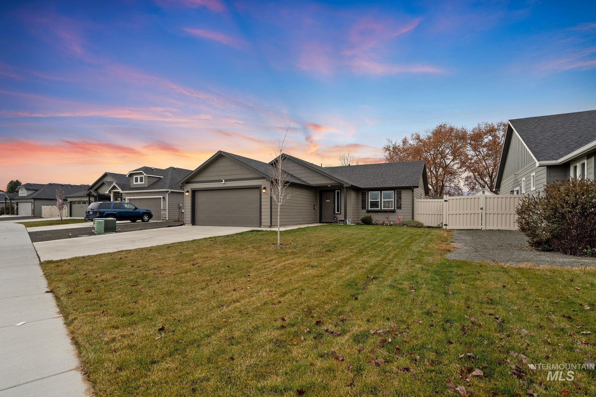 Single story home with a gate, concrete driveway, and a garage