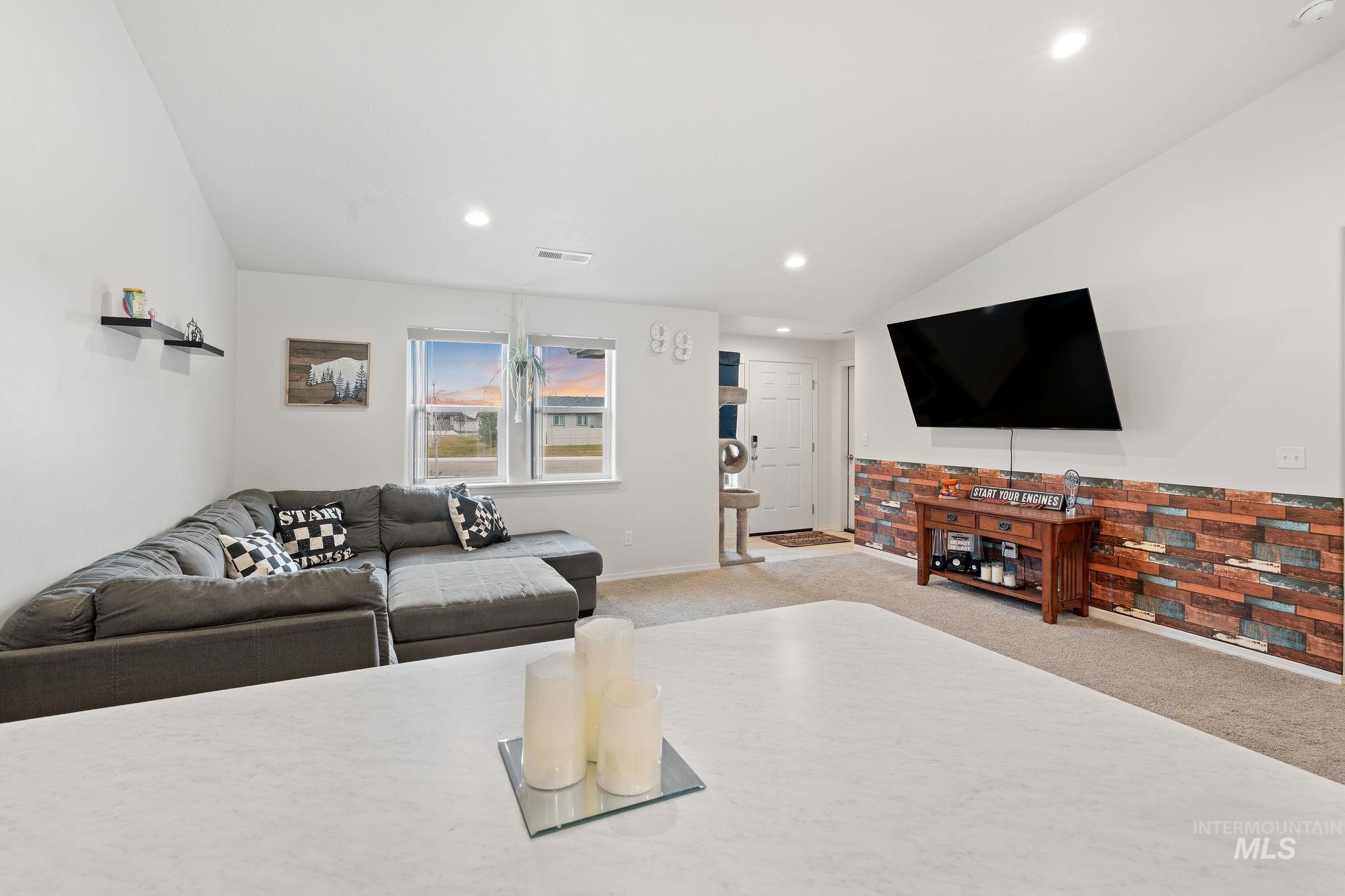 Living room with carpet floors, lofted ceiling, and recessed lighting