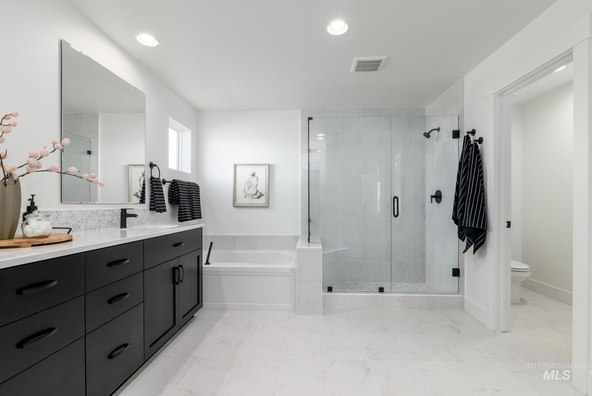 Full bathroom featuring a bath, vanity, a stall shower, and recessed lighting