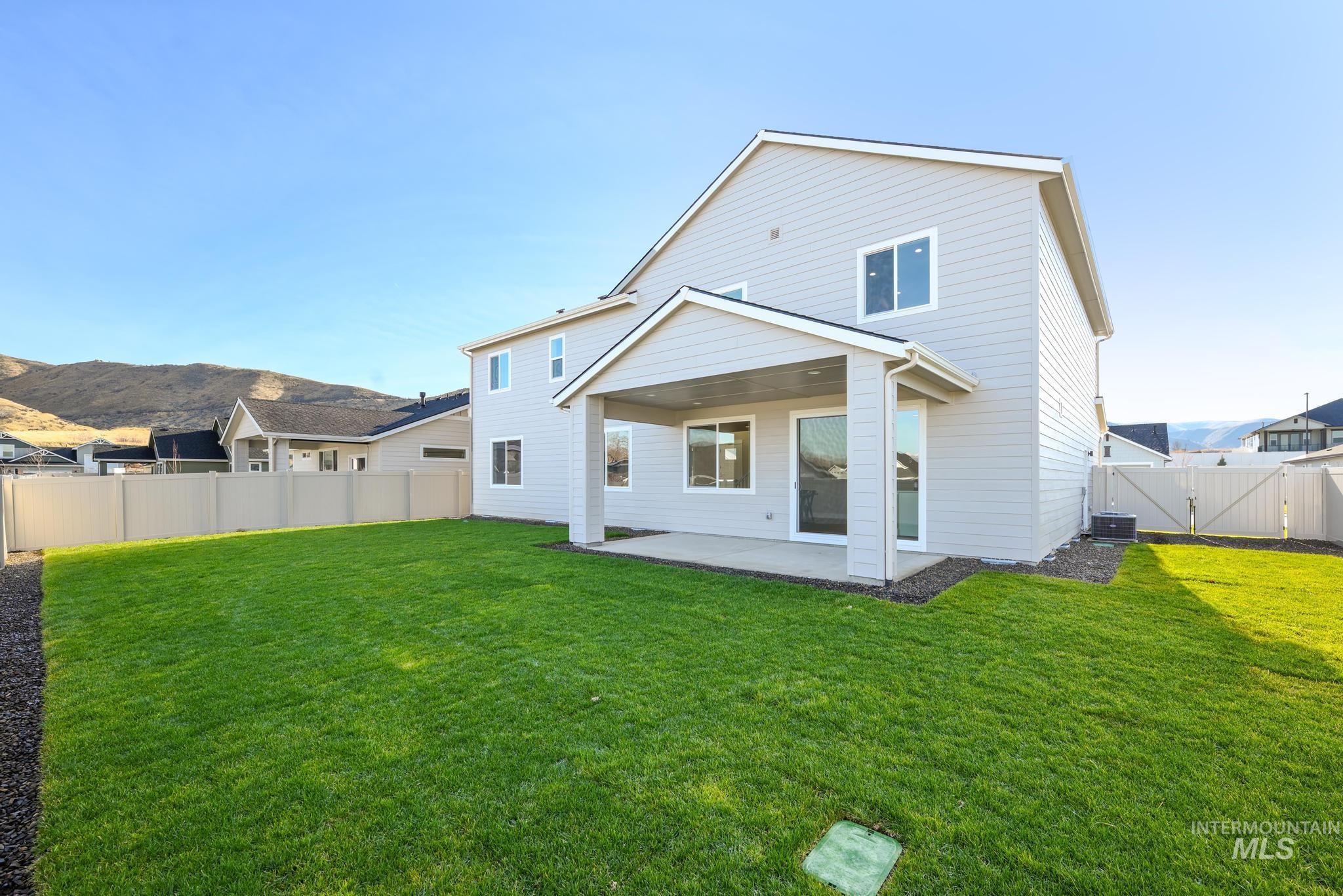 Rear view of property featuring a patio area, a fenced backyard, a gate, and a mountain view