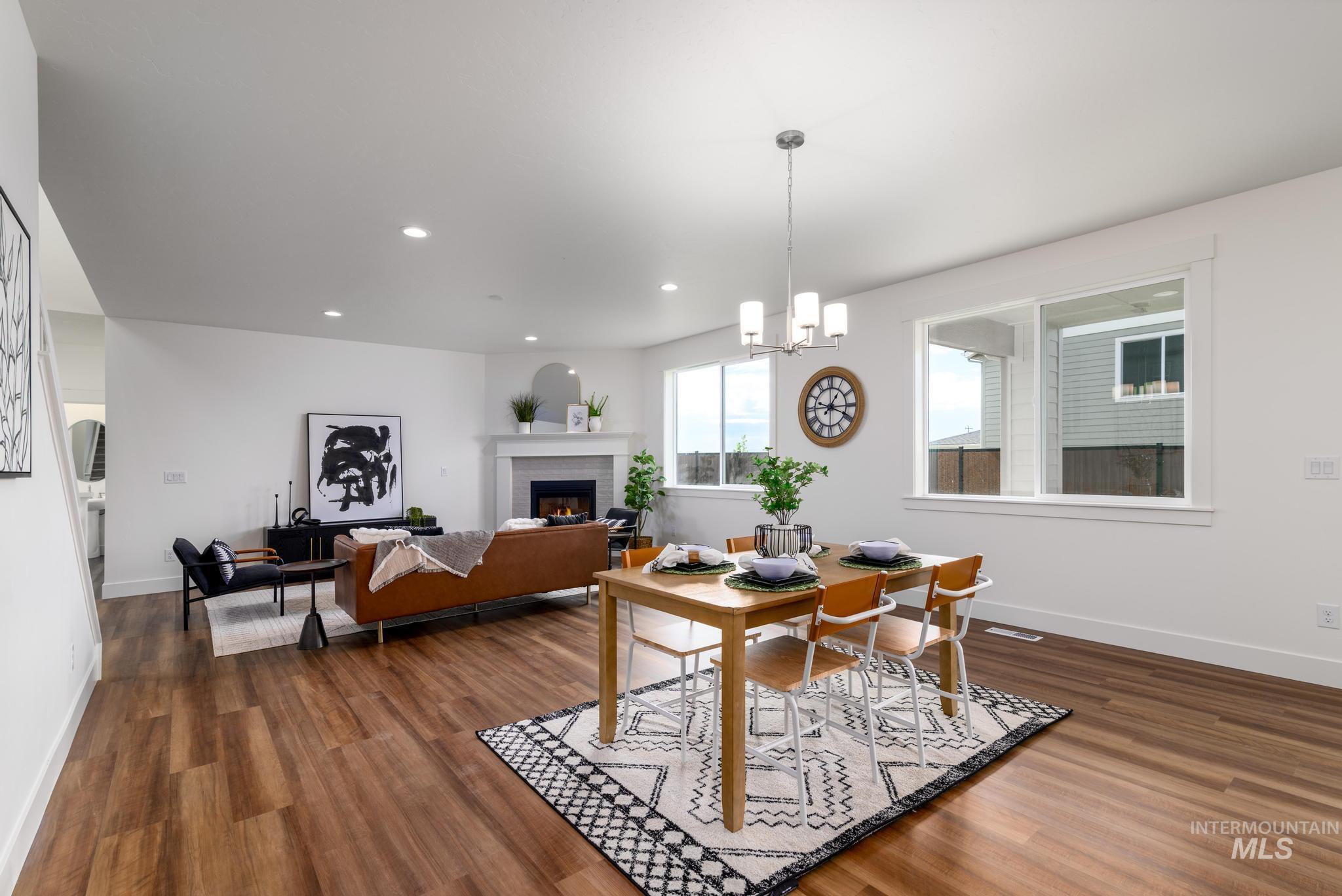 Dining space with dark wood finished floors, a fireplace, recessed lighting, and a chandelier