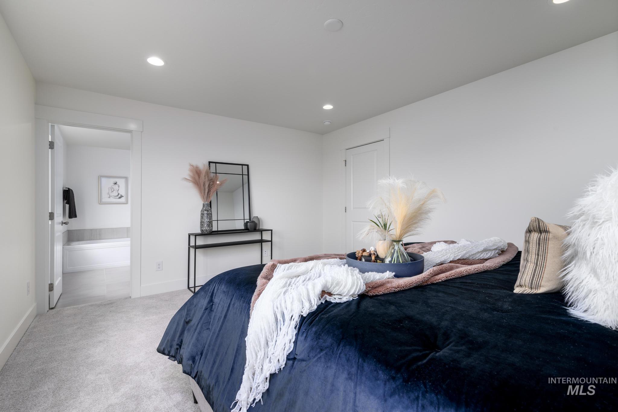 Bedroom featuring carpet floors, recessed lighting, and connected bathroom