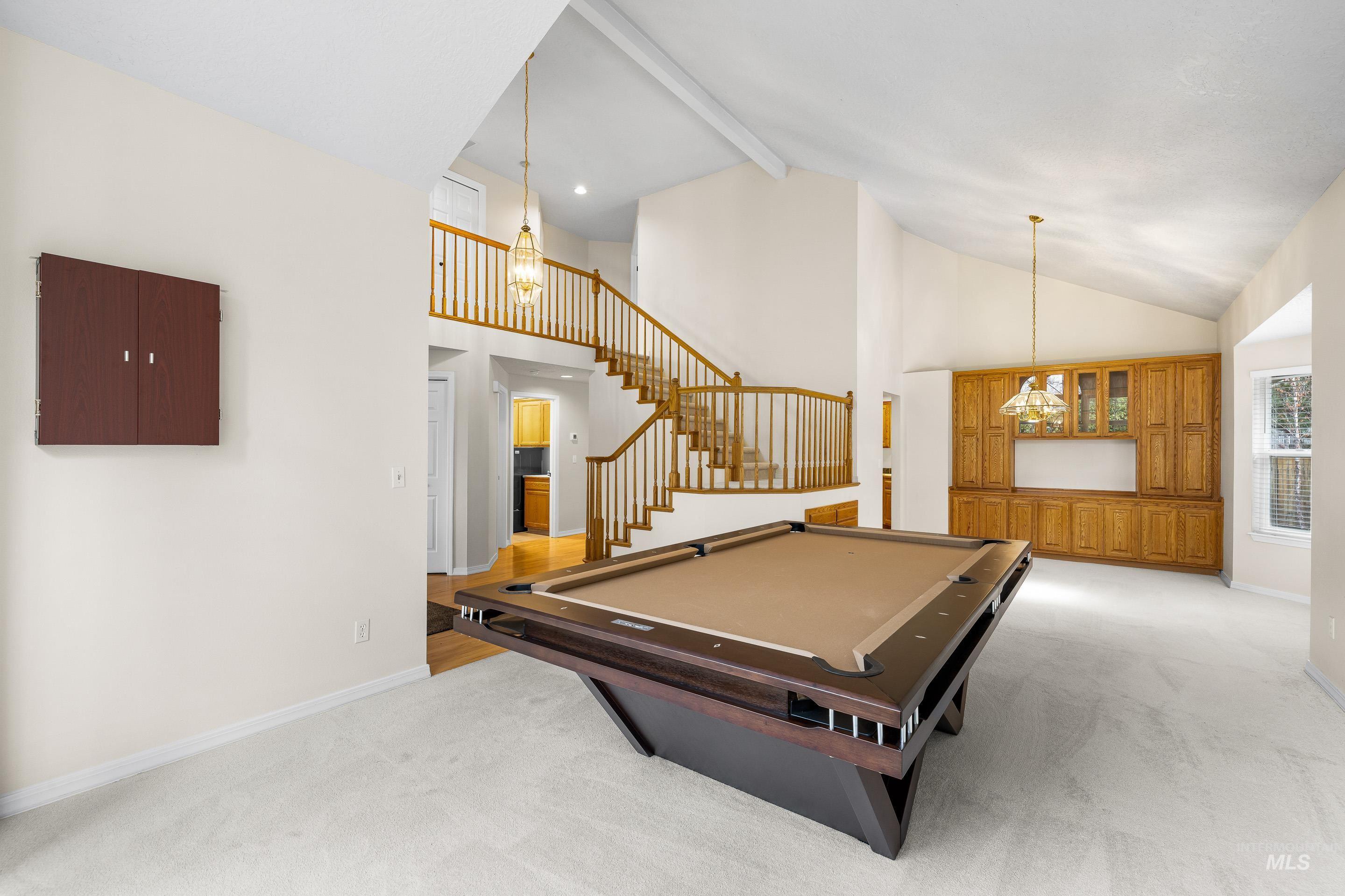 Playroom with beamed ceiling, pool table, high vaulted ceiling, light carpet, and a chandelier