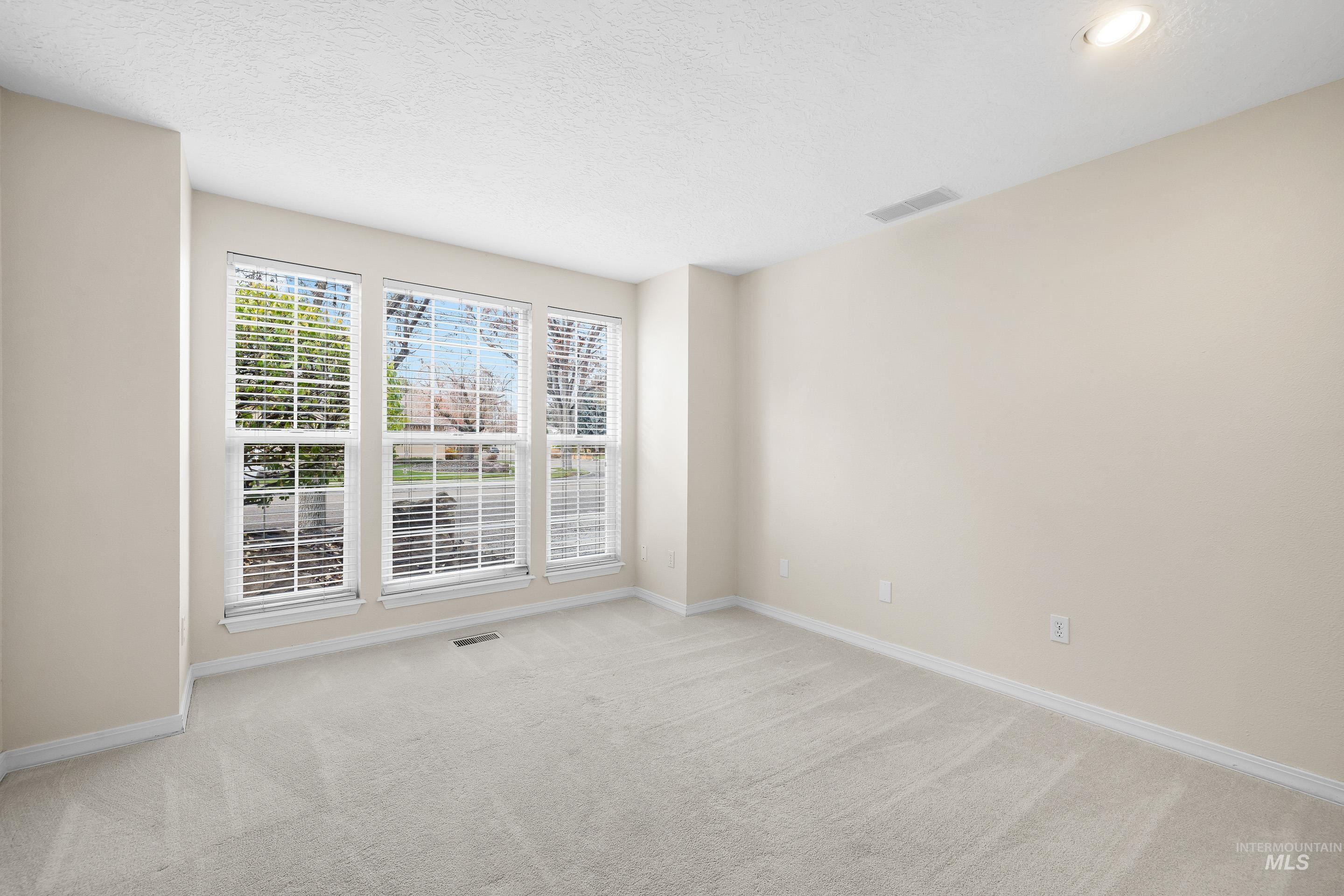Spare room featuring a textured ceiling and light colored carpet