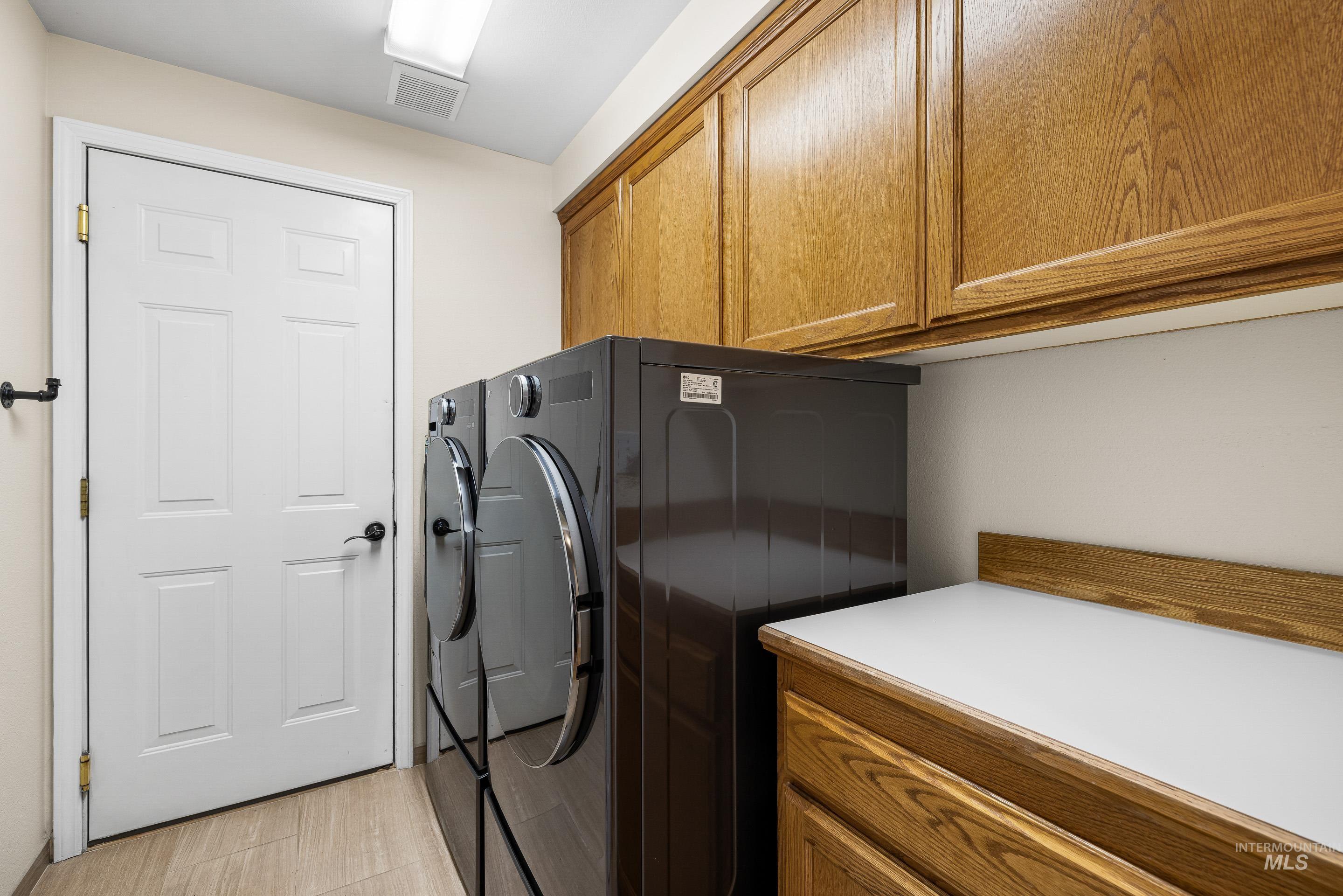 Laundry area featuring washing machine and dryer and cabinet space