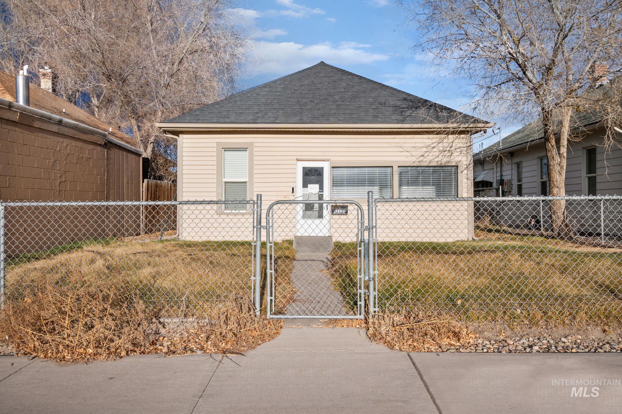 Back of house featuring a gate and roof with shingles