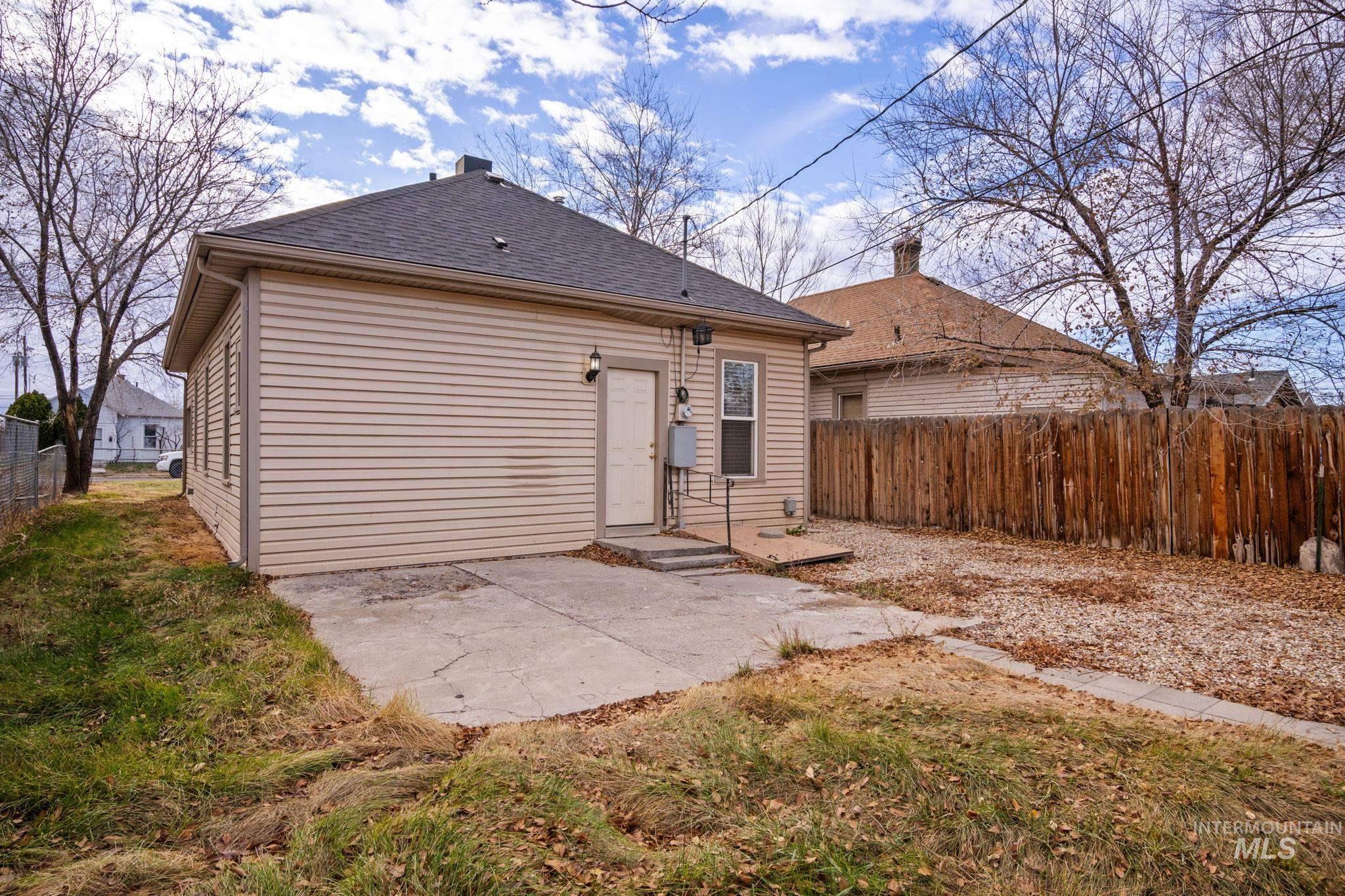 Rear view of property featuring a patio and a shingled roof