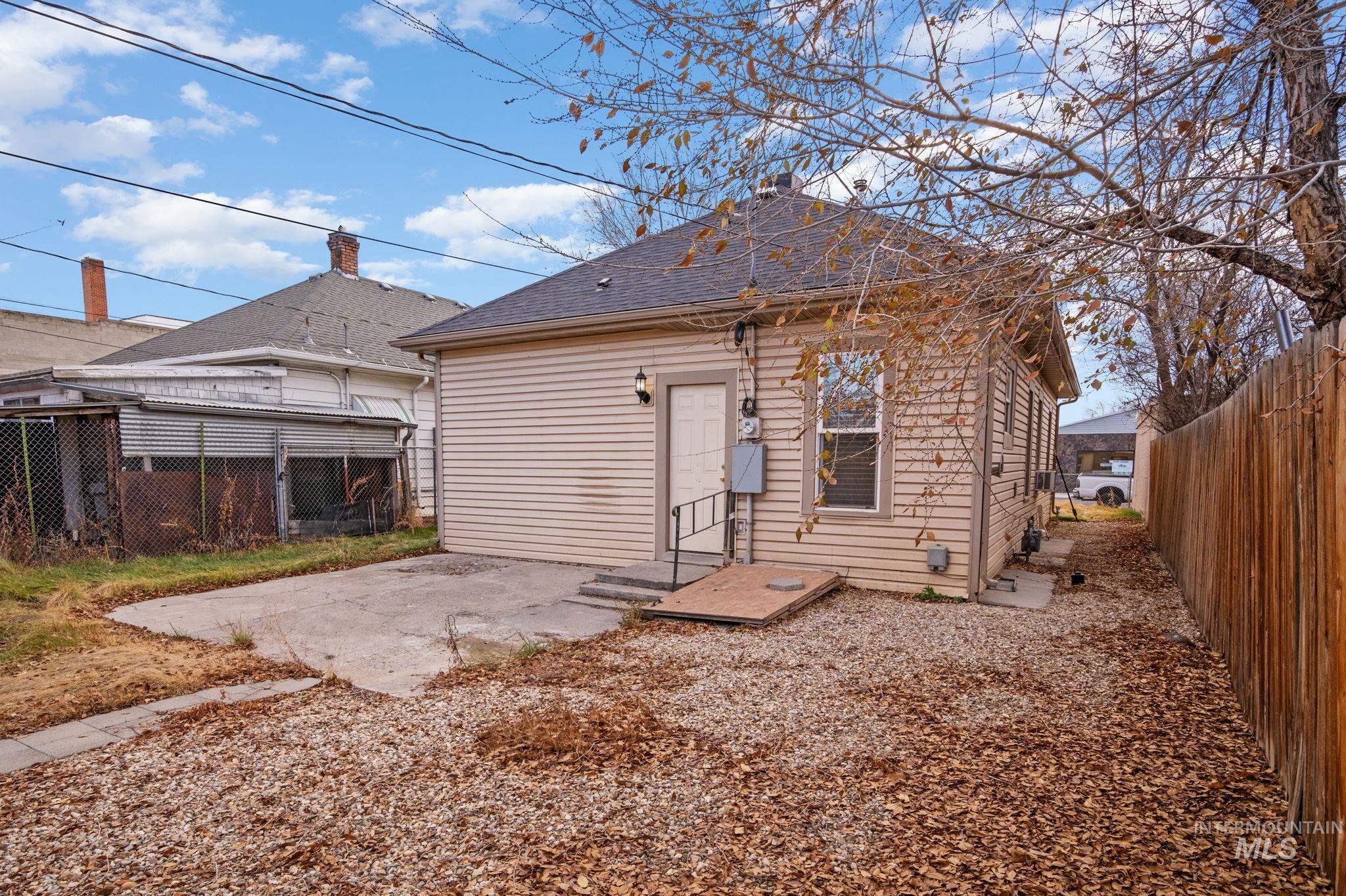 Rear view of property with a fenced backyard, a patio, and a shingled roof