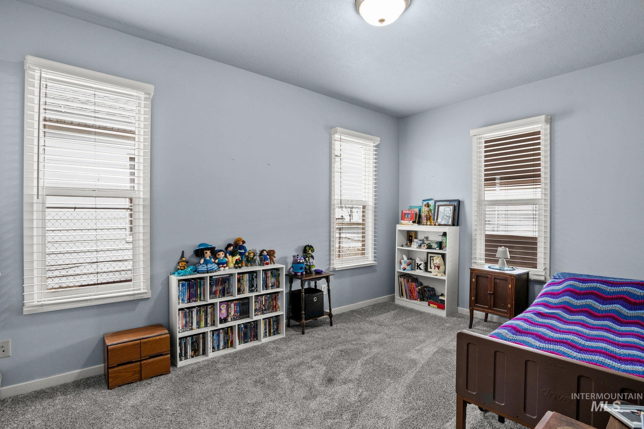 Bedroom with baseboards and light carpet