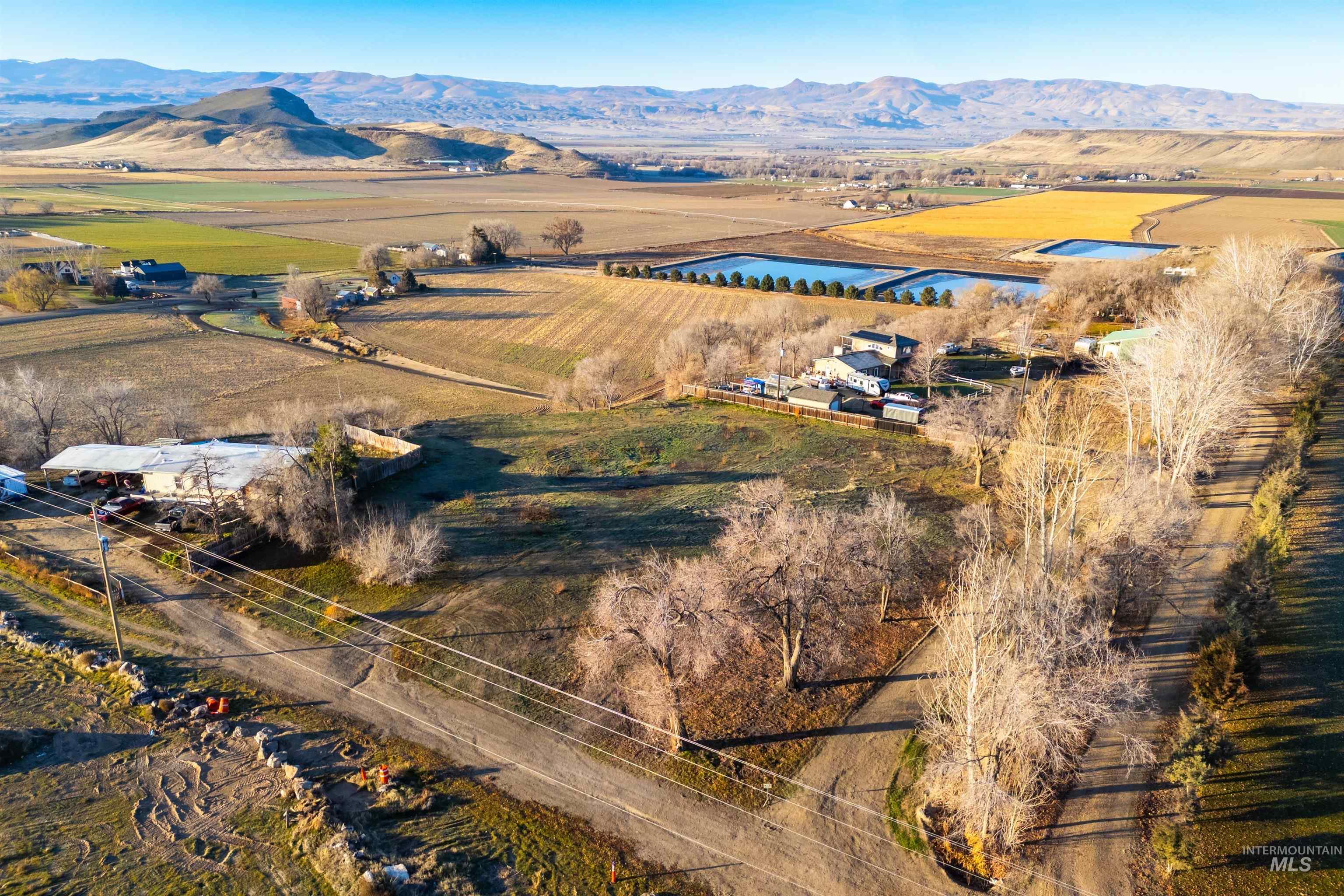 Aerial view of sparsely populated area with a mountain backdrop and extensive farmland