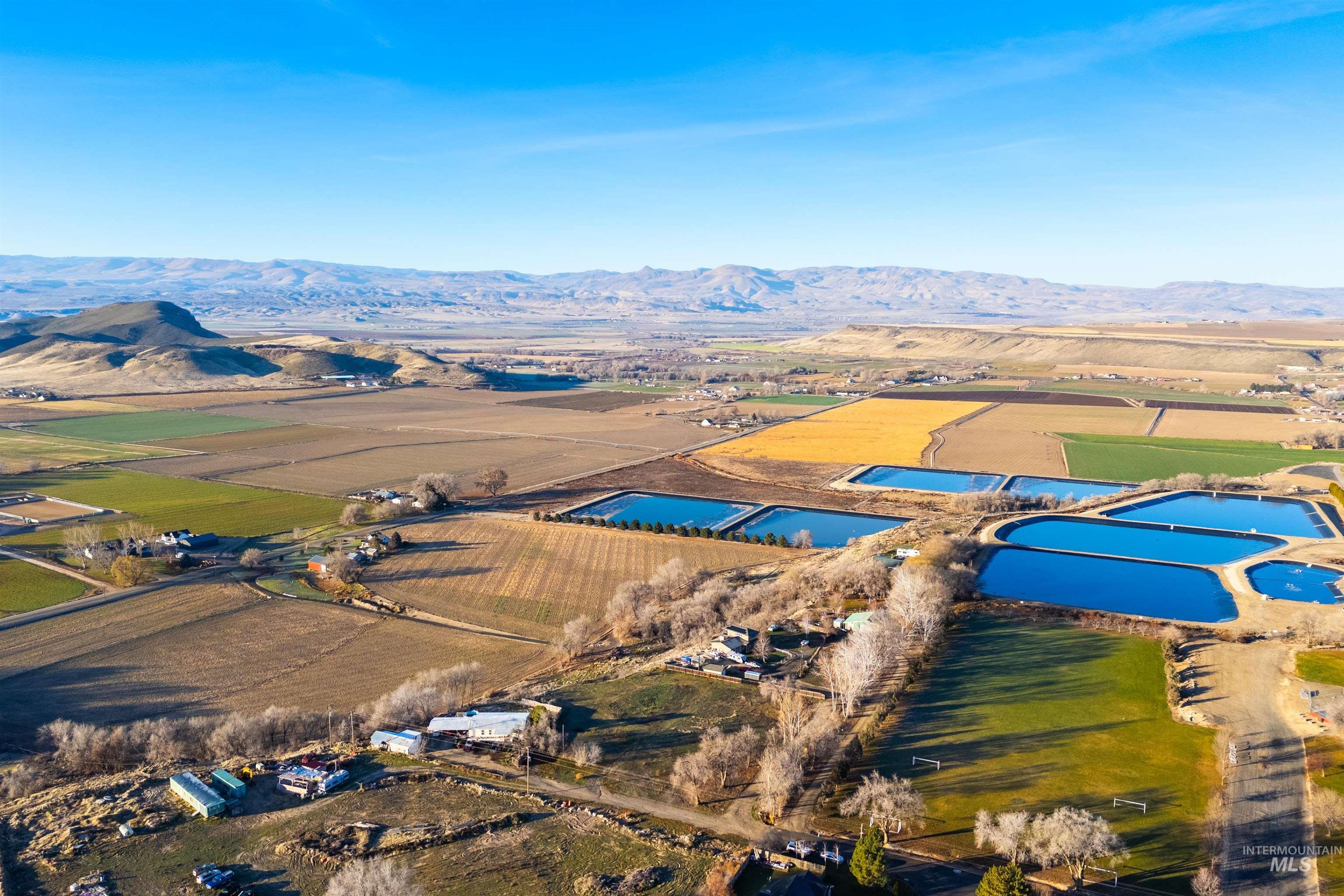 Overview of rural landscape featuring mountains and rows of crops