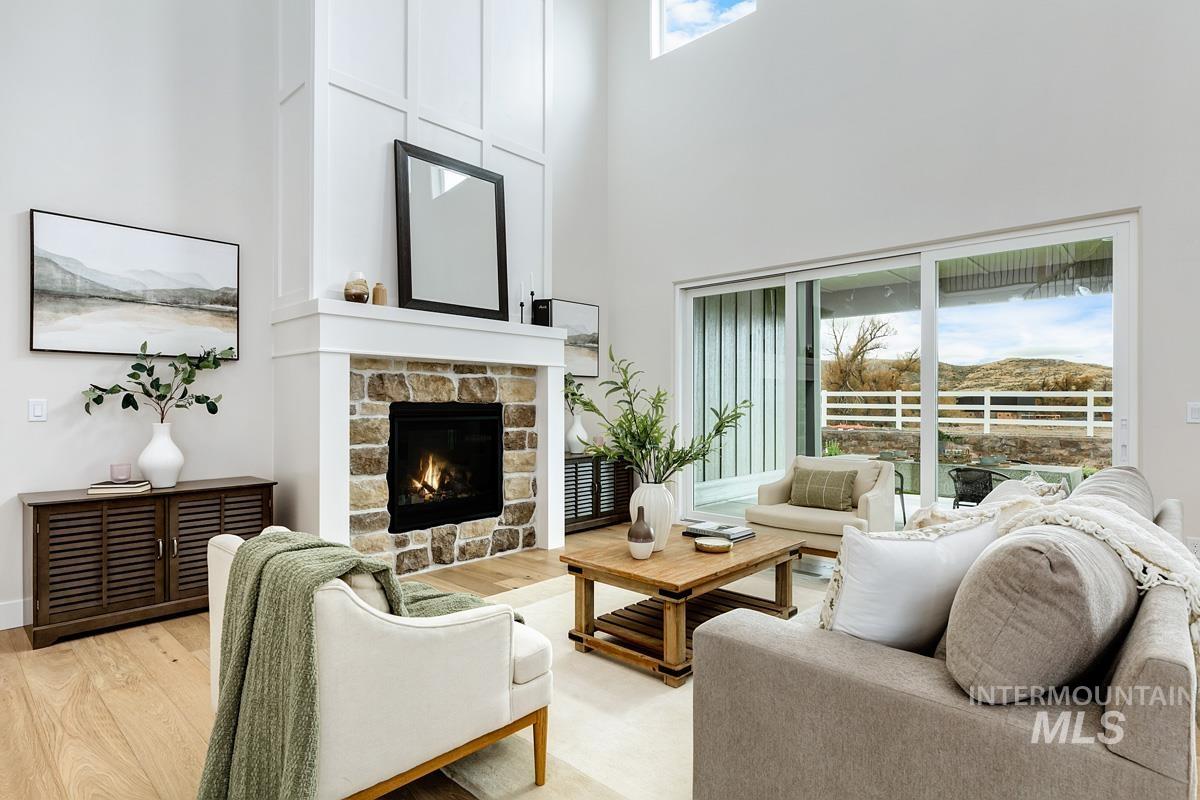 Living area featuring a high ceiling, a fireplace, and light wood-style flooring