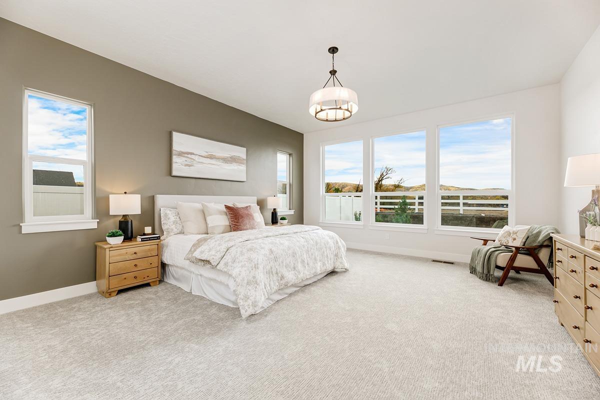 Bedroom featuring light carpet and multiple windows