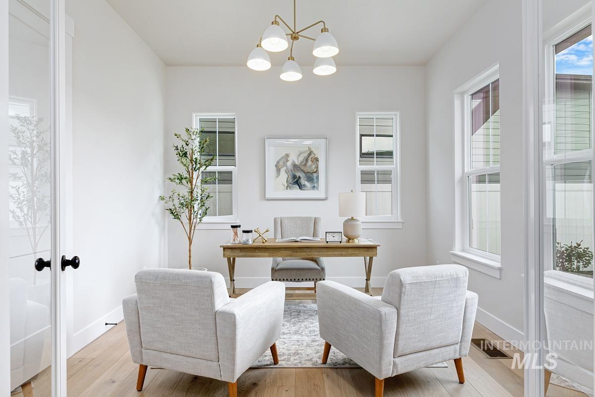 Office space featuring a chandelier, light wood finished floors, and french doors