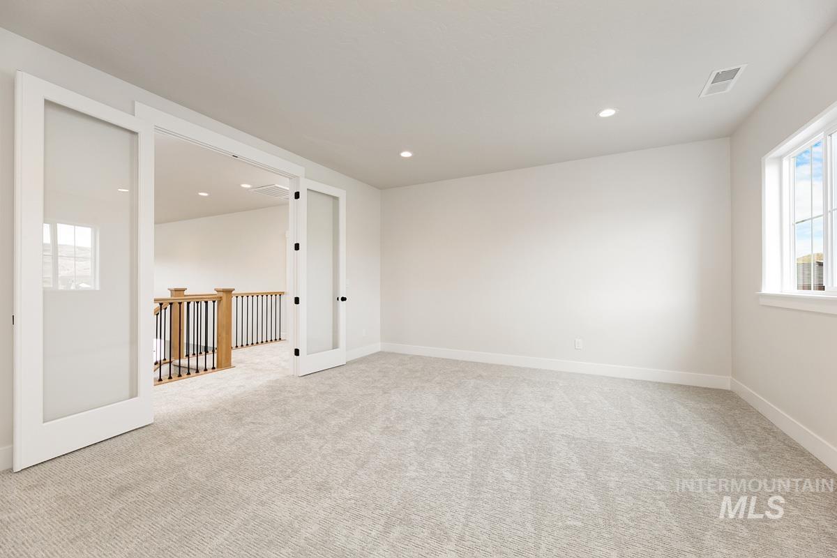 Unfurnished room featuring plenty of natural light, light colored carpet, and recessed lighting