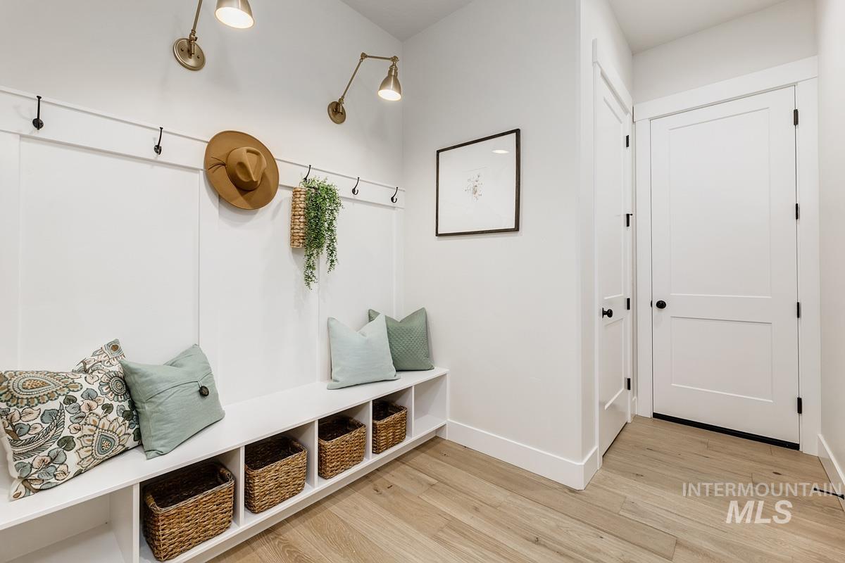 Mudroom with light wood finished floors and baseboards