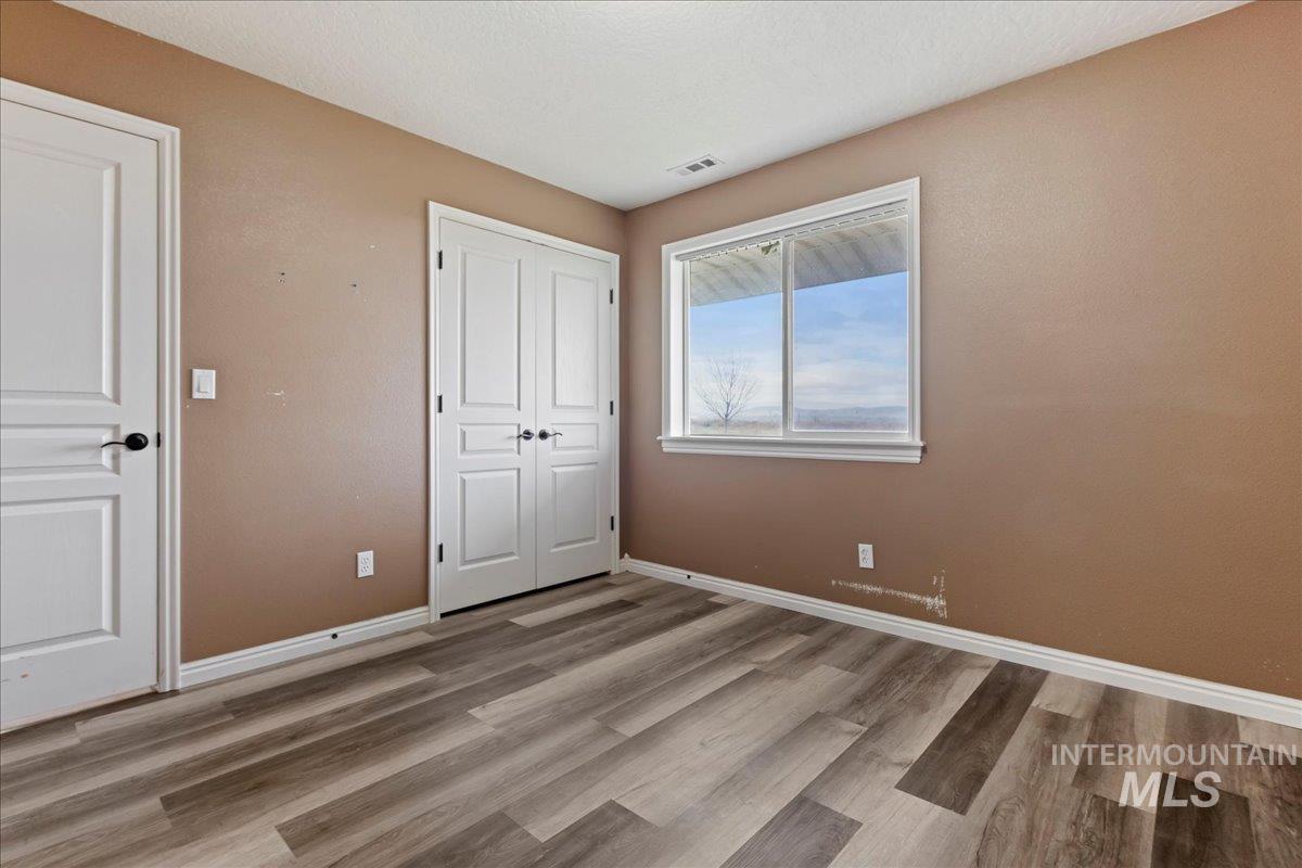 Unfurnished bedroom with light wood-type flooring and a closet