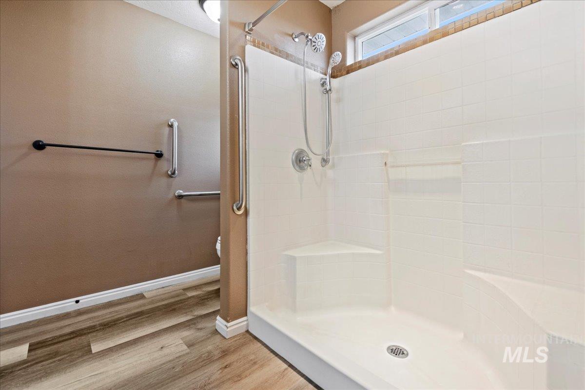 Full bathroom featuring light wood-type flooring and a shower