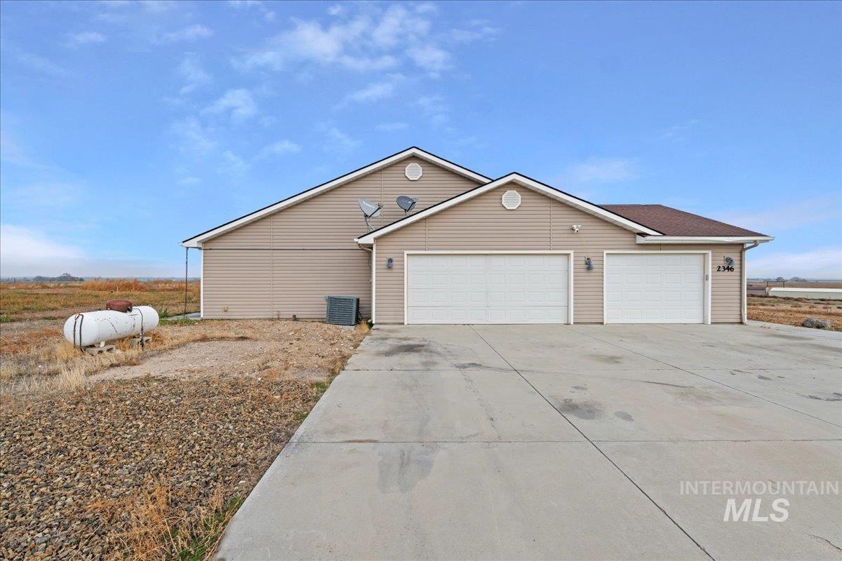 View of side of home featuring driveway and a garage