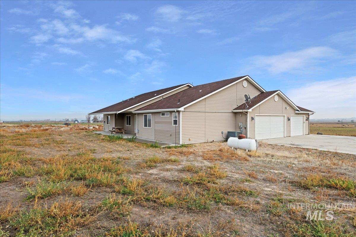 View of home's exterior with a patio area, driveway, and an attached garage