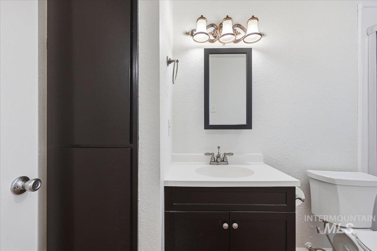 Bathroom with a textured wall and vanity
