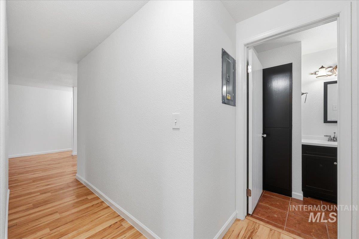 Corridor with light wood-style floors and electric panel