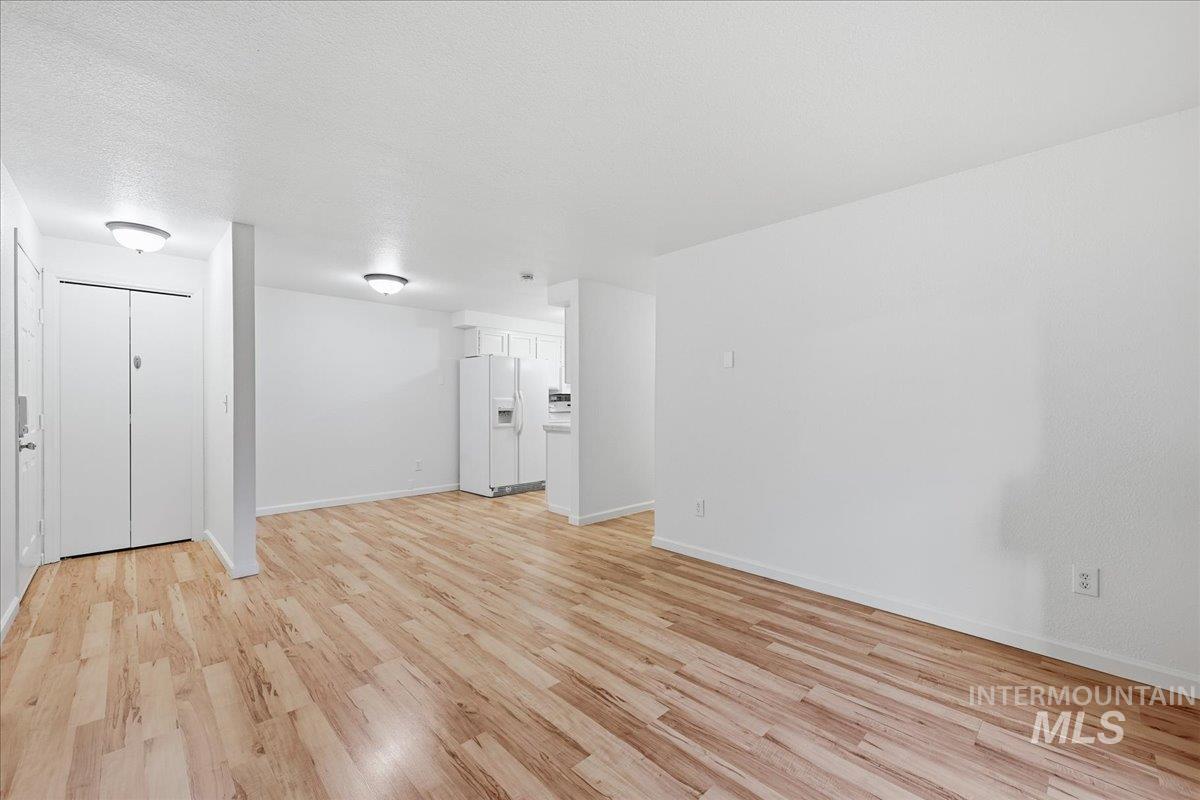 Unfurnished room with light wood-style flooring and a textured ceiling