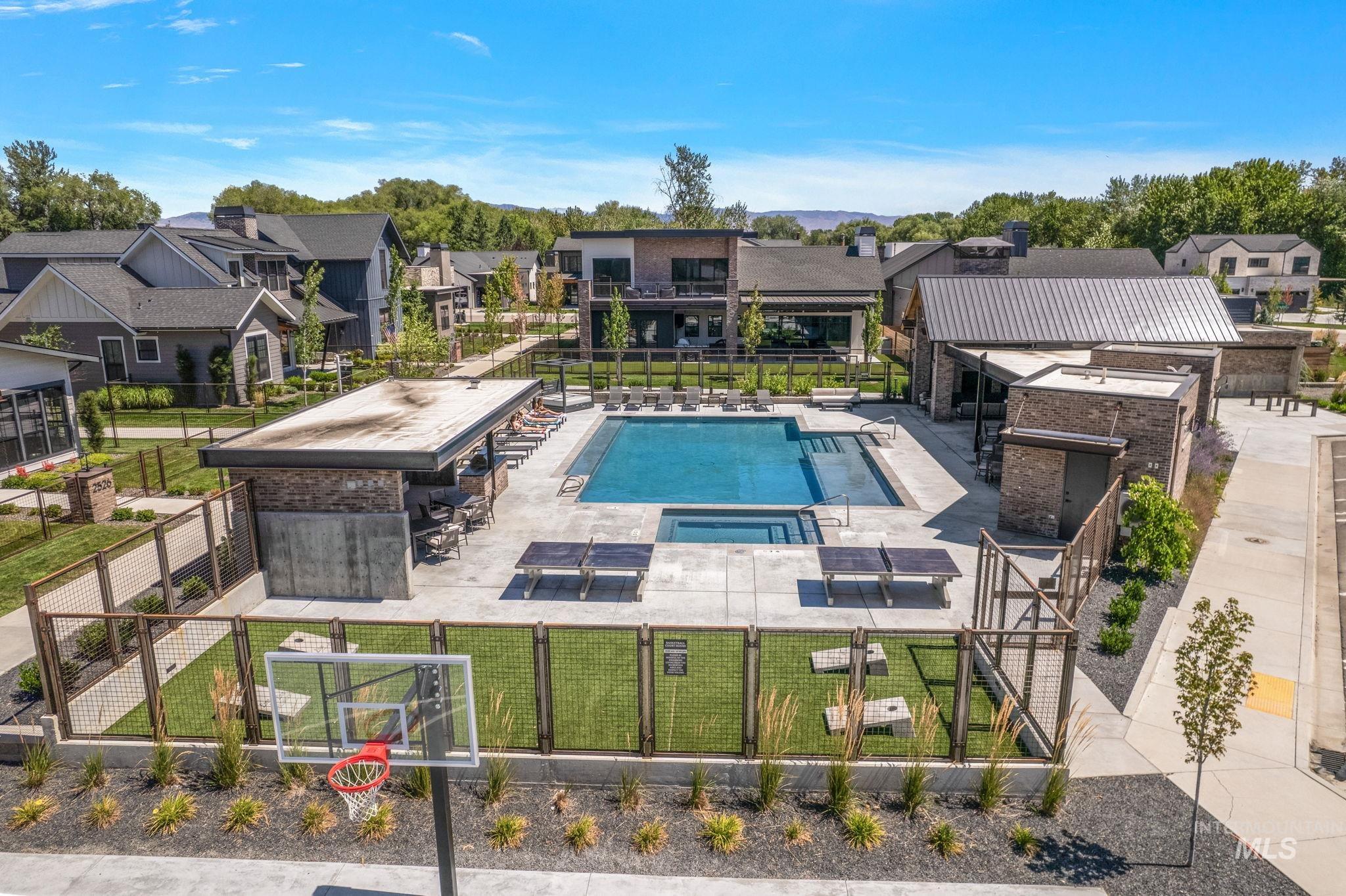 Community pool with a patio area, a hot tub, BBQ, fireplace, cornhole, ping pong & shuffle board.