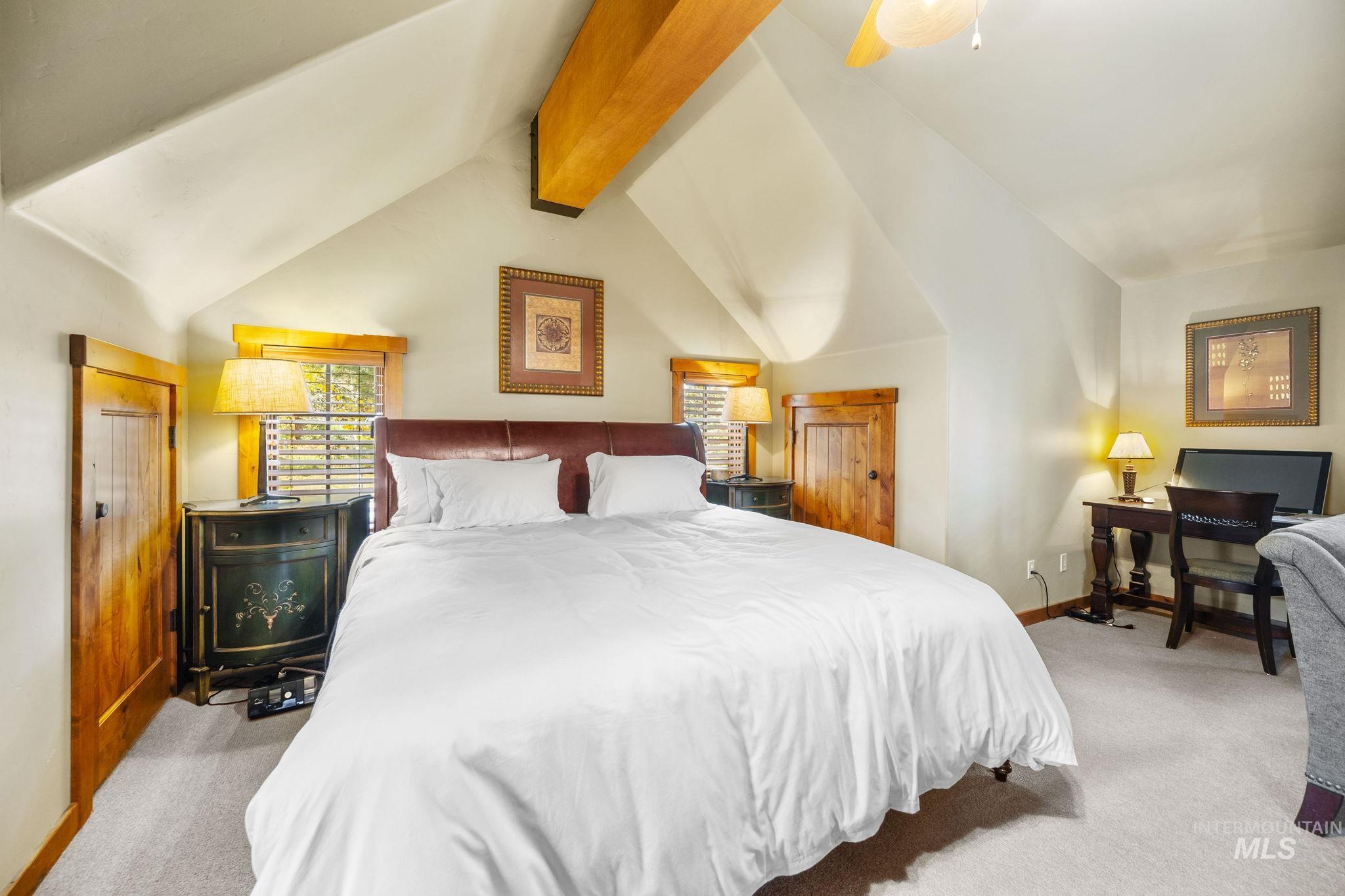 Bedroom featuring light carpet, a ceiling fan, and an office area